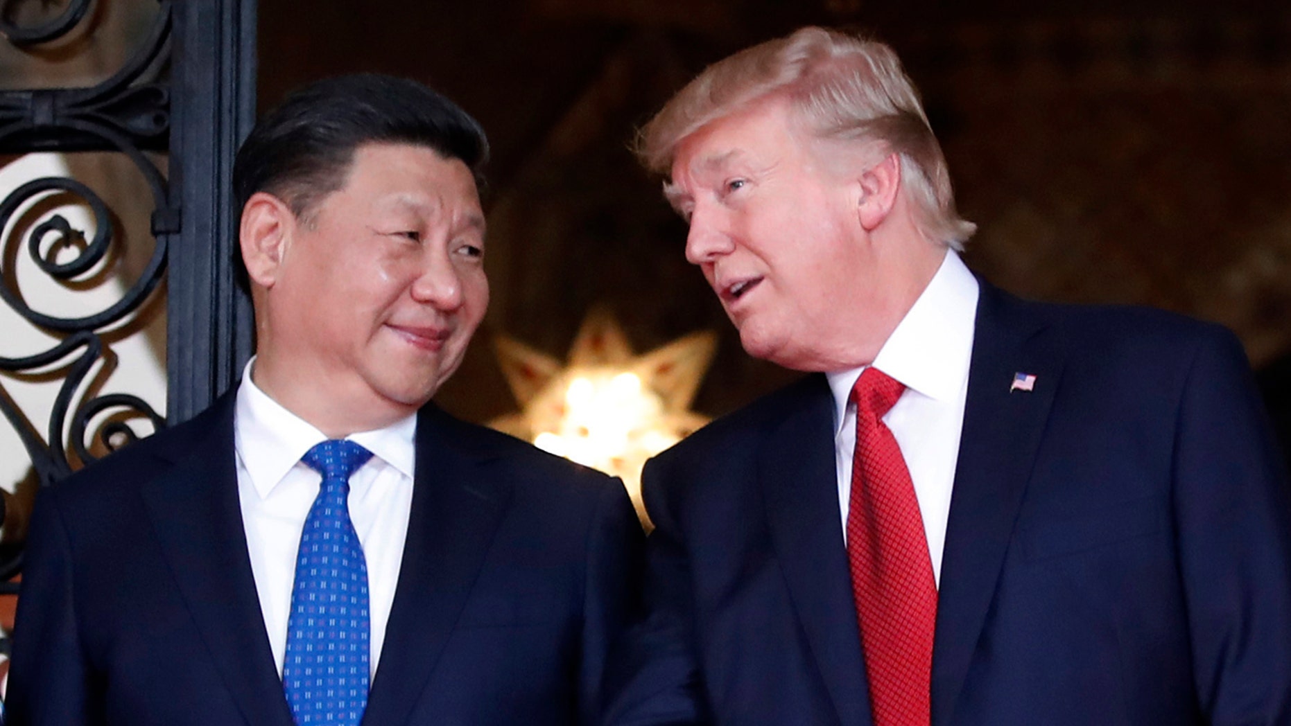 In this April 6, 2017 file photo, Chinese President Xi Jinping, left, smiles at U.S. President Donald Trump as they pose together with their wives for photographers before dinner at Mar-a-Lago in Palm Beach, Fla.