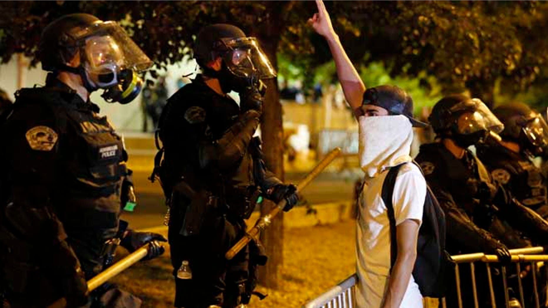 FILE - In this May 24, 2016, file photo, riot police block off the Albuquerque Convention Center to anti-Trump protests following a rally and speech by Republican presidential candidate Donald Trump at the convention center where the event was held, in Albuquerque, N.M. Activists say peaceful protesters have been unfairly targeted by Albuquerque police who announced they were searching for suspects connected to the demonstration that turned violent. (AP Photo/Brennan Linsley, File)
