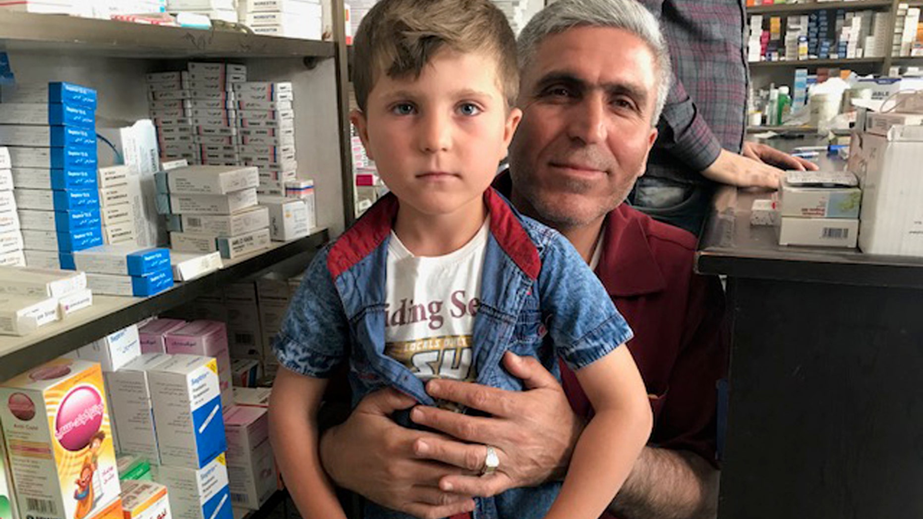 Rezgar Ramadan holding his five-year-old son, Trump, who was renamed after the 2016 presidential election.