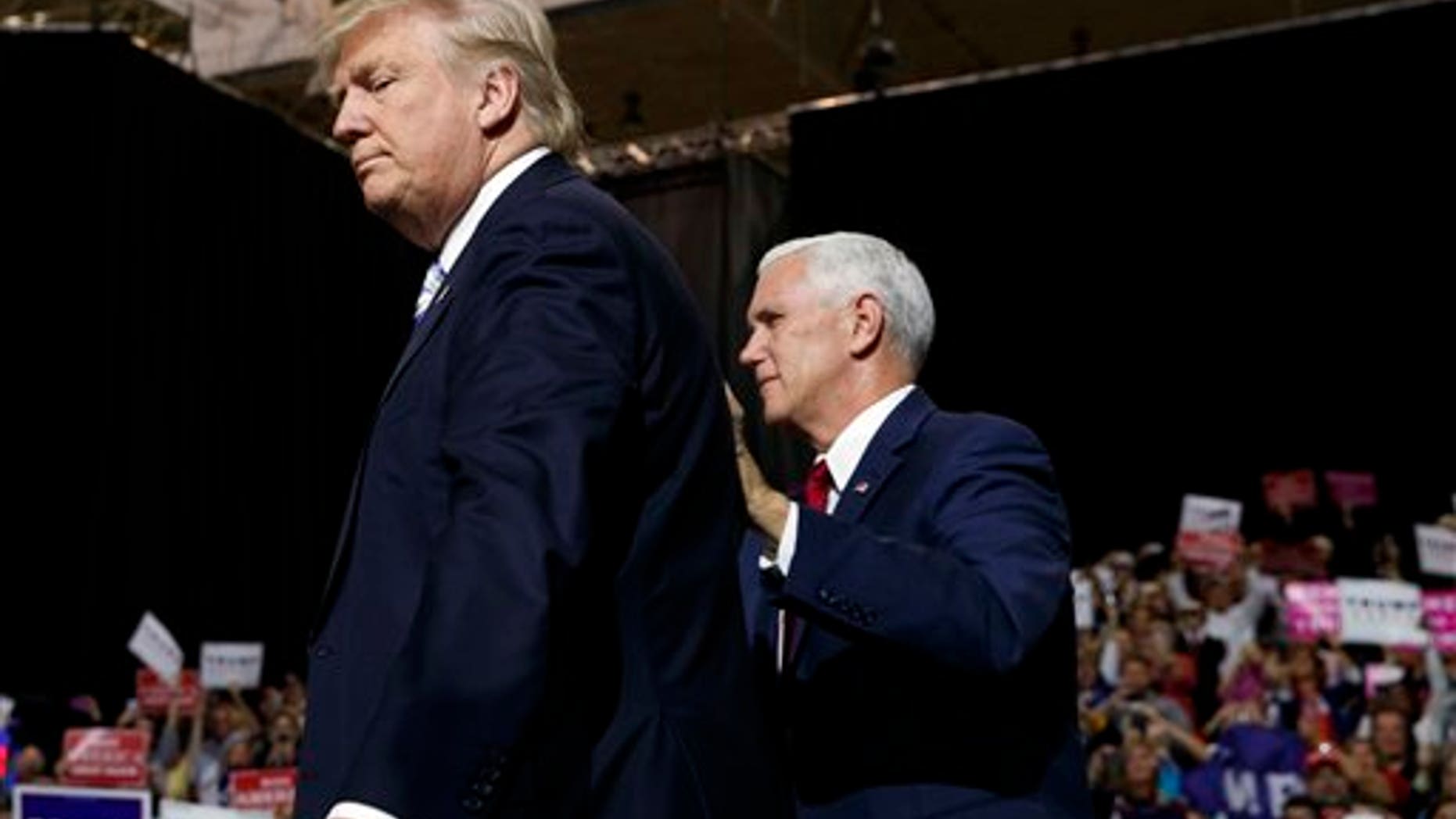 Republican presidential candidate Donald Trump, left, is accompanied by his running mate, Governor of Indiana, Mike Pence, during a campaign rally in Cleveland, Ohio, on Saturday October 22, 2016.