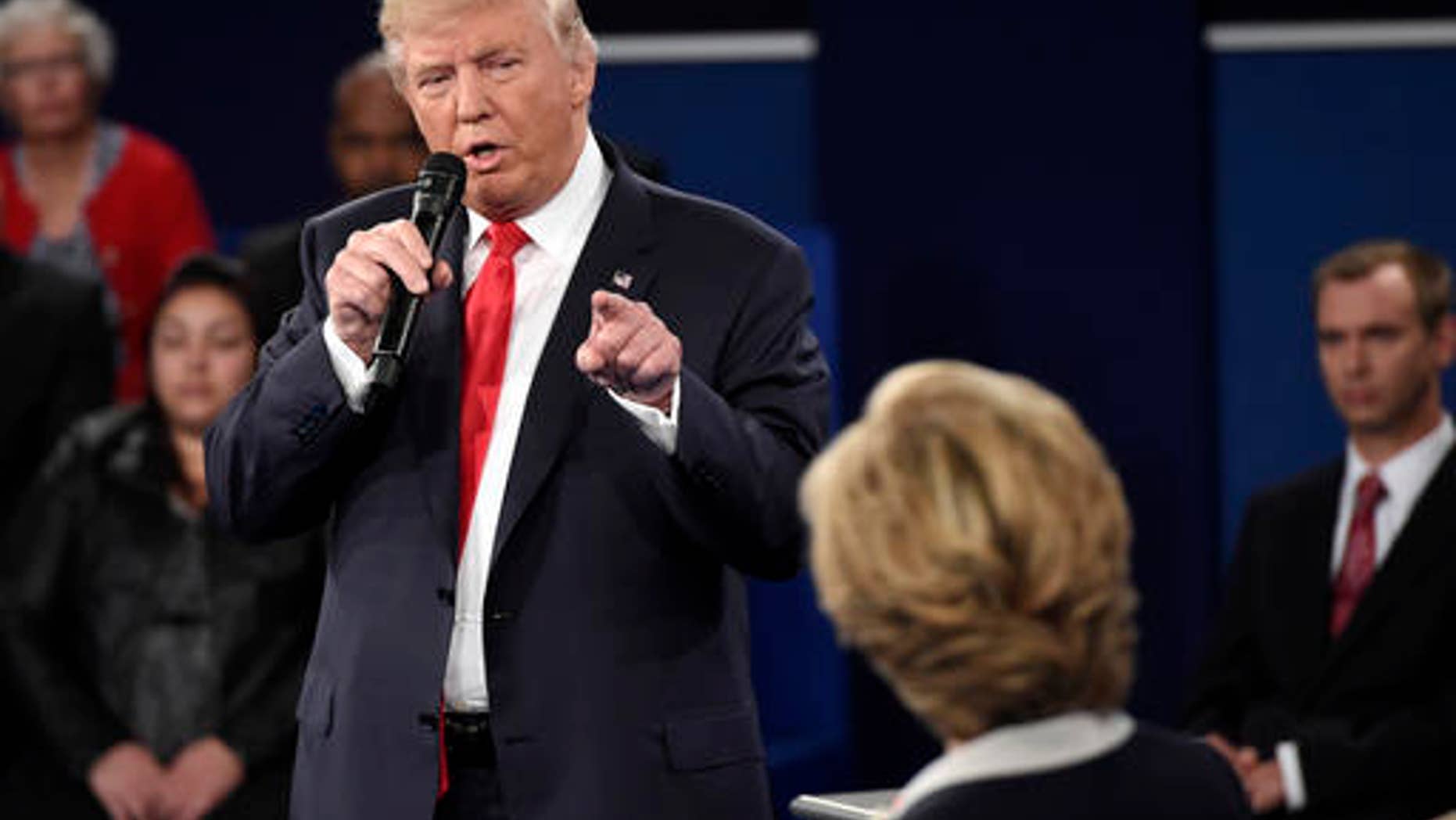 FILE - Republican presidential nominee Donald Trump points at Democratic presidential nominee Hillary Clinton as he speaks during the second presidential debate at Washington University in St. Louis, Sunday, Oct. 9, 2016.