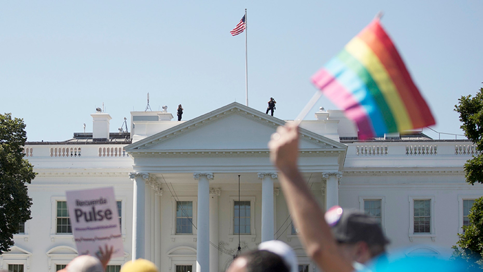 In this Sunday, June 11, 2017 file photo, Equality March for Unity and Pride participants march past the White House in Washington.