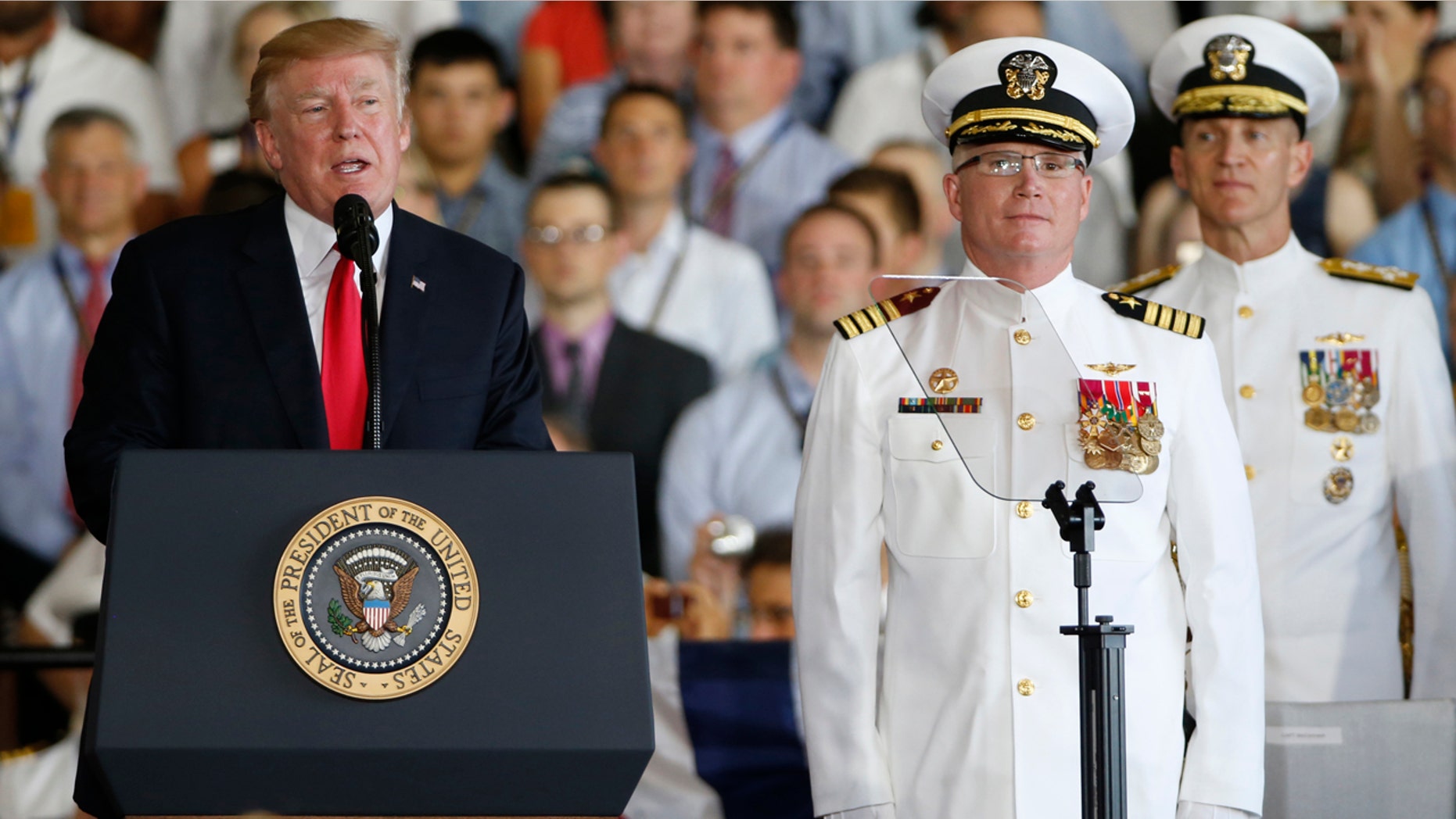 President Donald Trump, left, puts the USS Gerald R Ford into commission as Ships commander Capt. Richard McCormack, front right, listens in Norfolk, Va. Saturday.