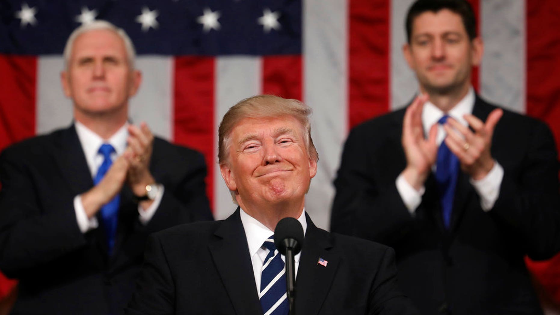 FILE - In this Feb. 28, 2017, file photo, President Donald Trump addresses a joint session of Congress on Capitol Hill in Washington, as Vice President Mike Pence and House Speaker Paul Ryan of Wis., applaud. President Trumpâs first state of the union speech will carry more suspense than most. (Jim Lo Scalzo/Pool Image via AP, File)
