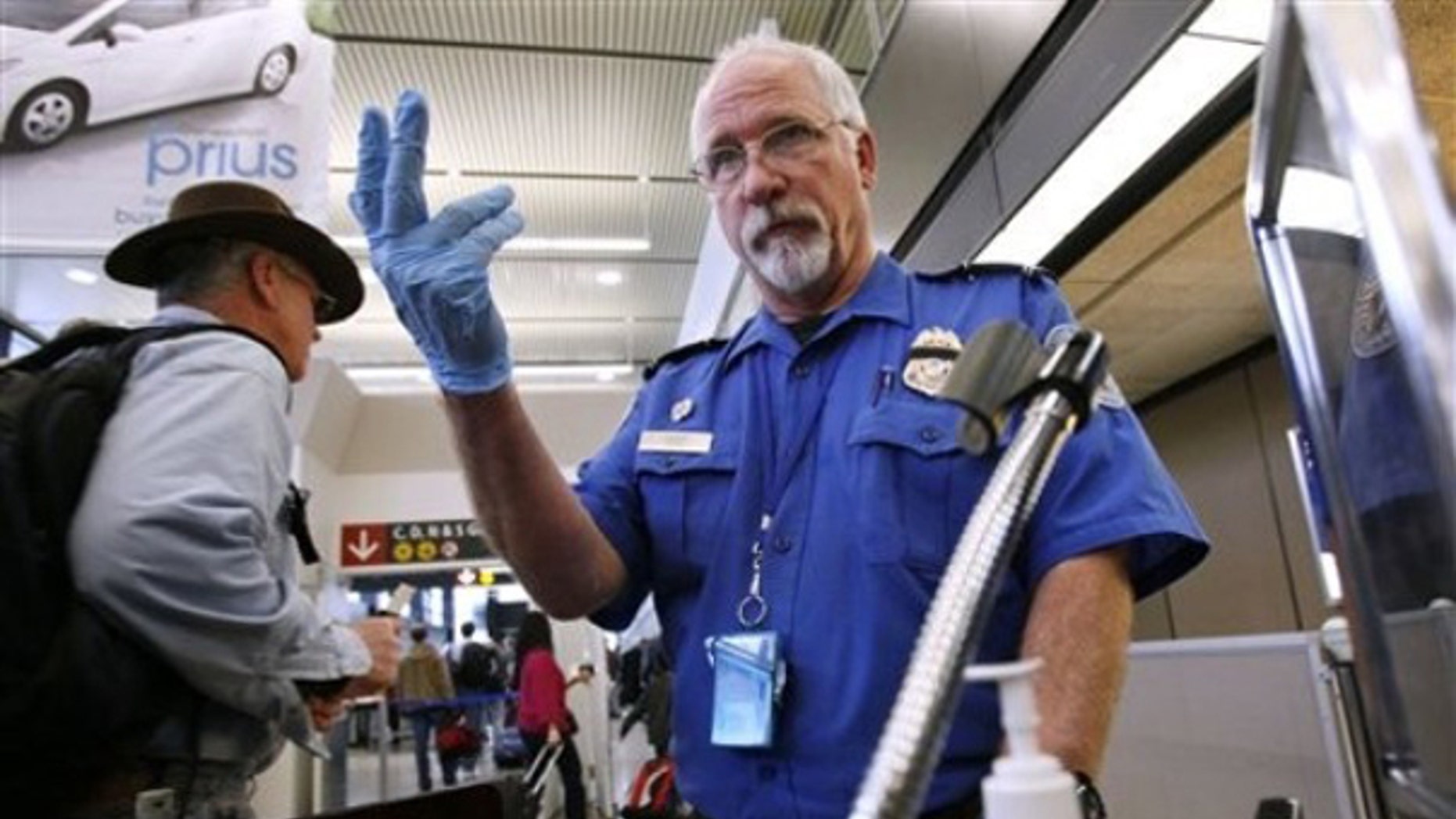 TSA officer Robert Howard signals an airline passenger forward at a security check-point at Seattle-Tacoma International Airport Jan. 4. (AP Photo)