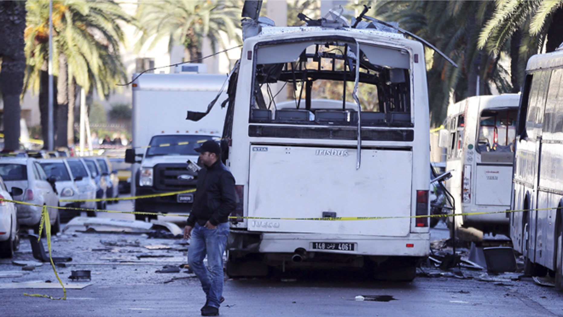 Nov. 25, 2015: A man walks past the bus that exploded Tuesday in Tunis.