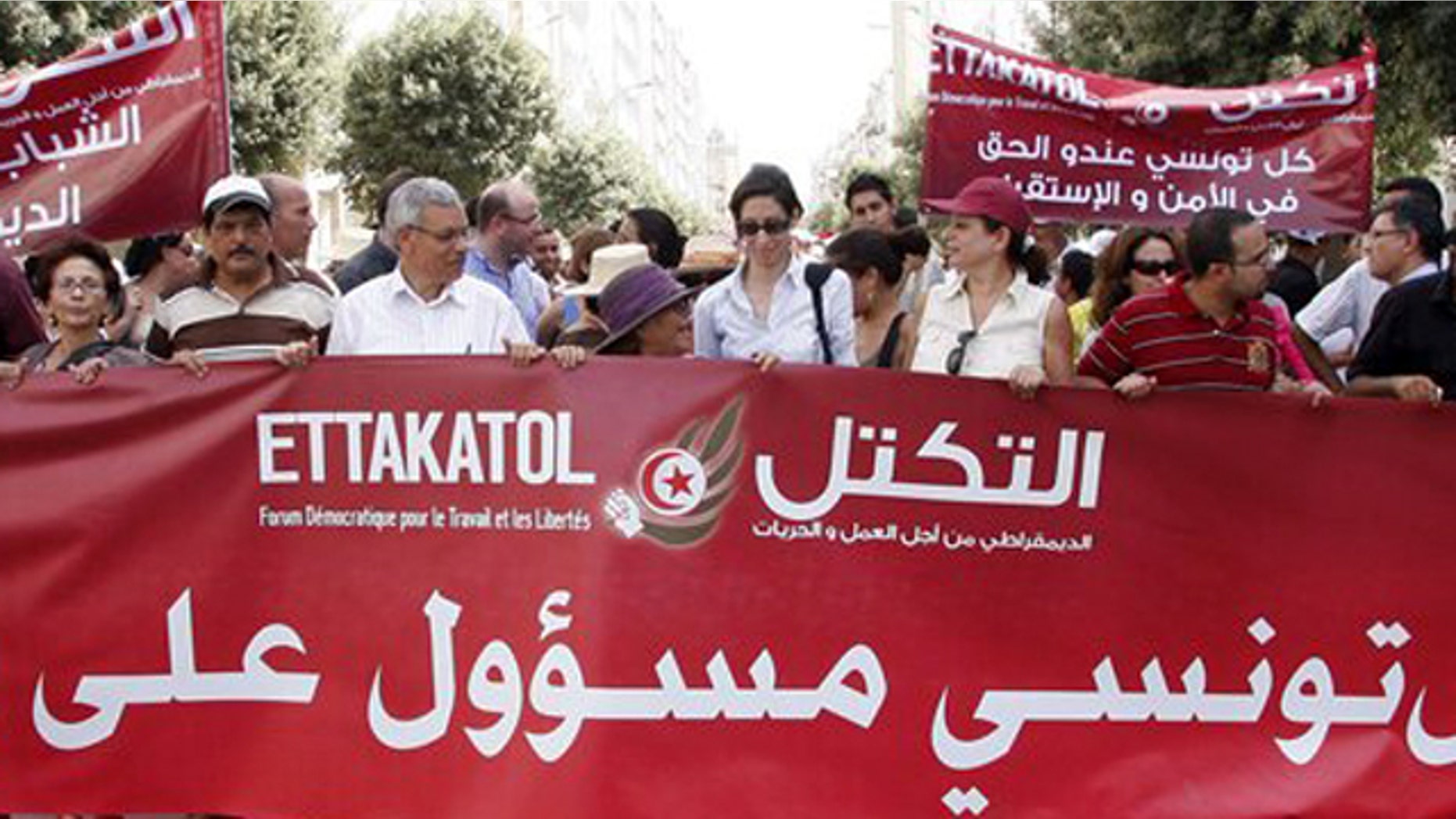 Demonstrators from a dozen of political parties hold a banner reading "Each Tunisian is responsible for his country" during a march against violence in Tunis , Thursday, July 21, 2011 as Tunisia prepares for landmark Oct. 23 elections for a body meant to write a new constitution. Banner at right behind reads: Any Tunisian has the right to security.