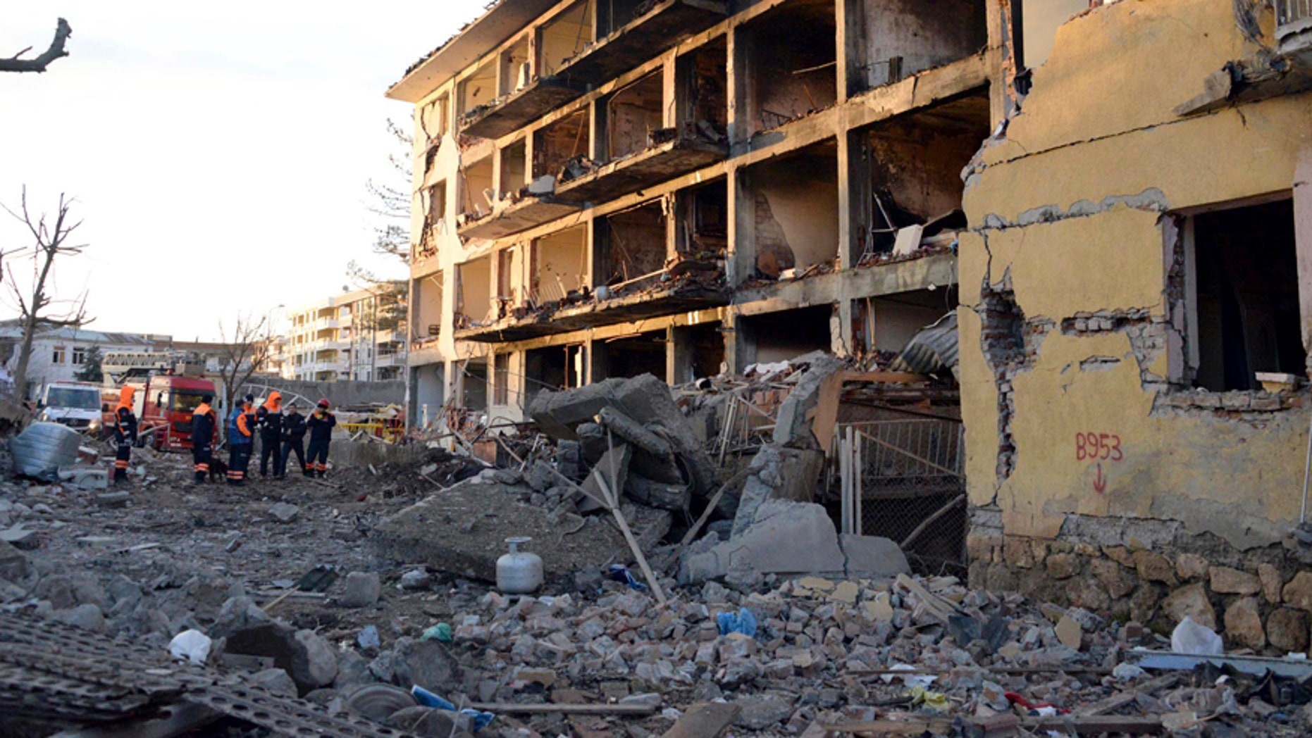 Jan. 14, 2016: A group of men stand in front of a destroyed police station in Cinar, in the mostly-Kurdish Diyarbakir province in southeastern Turkey.