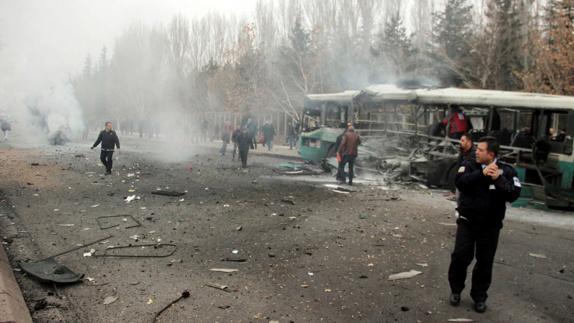 Security officials and people at the scene of a car bomb attack in central Anatolian city of Kayseri, Turkey, Saturday, Dec. 17, 2016.