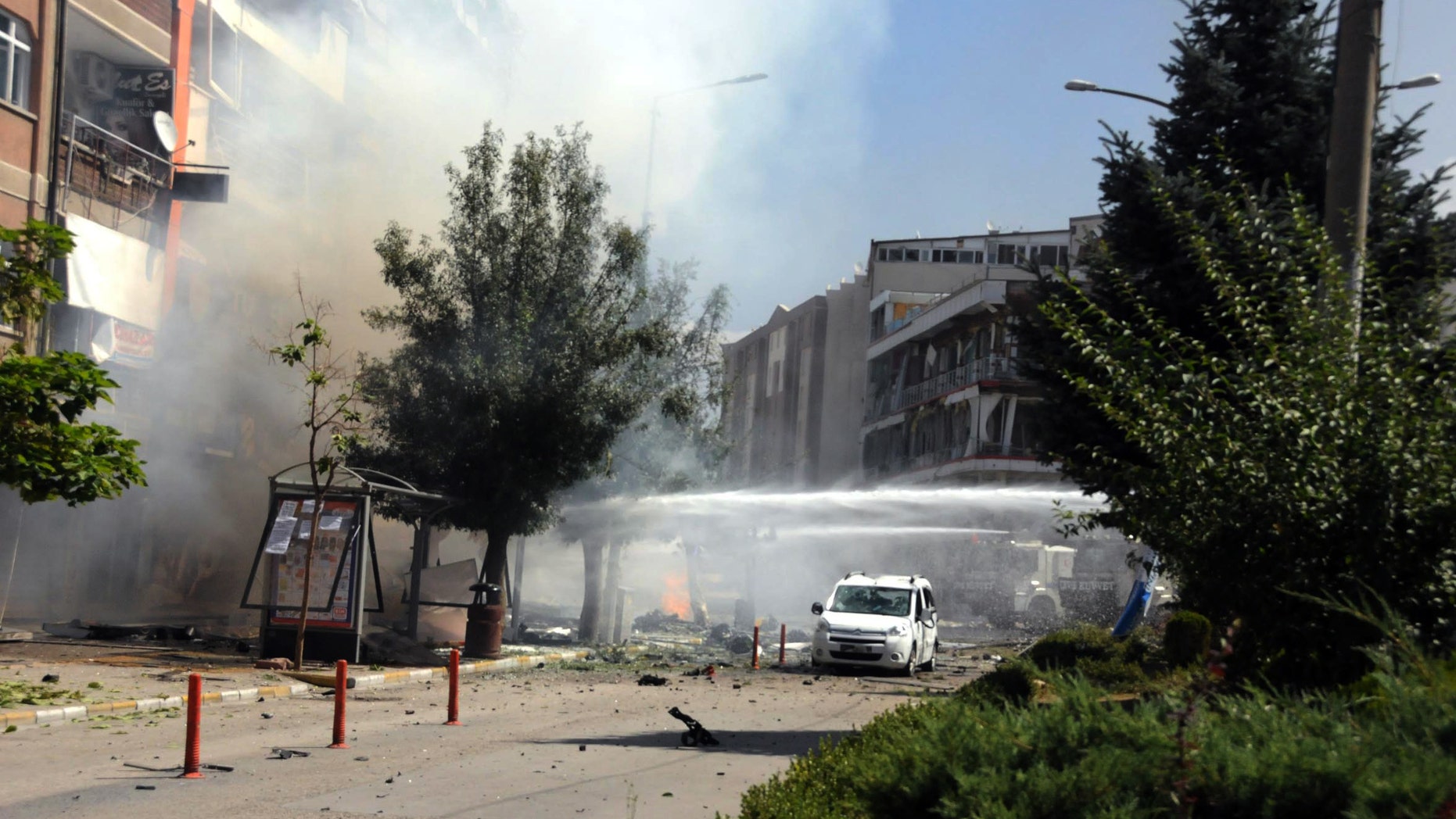 Firefighters work to extinguish a fire after a car bomb attack in the city center of Van.