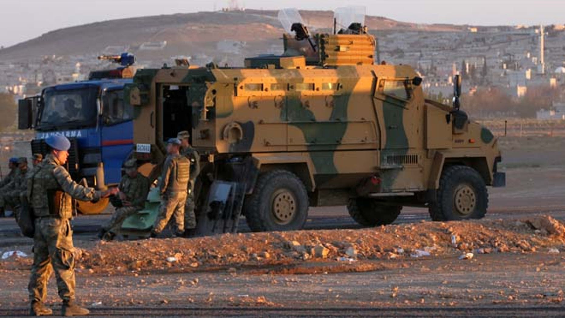 Oct. 1, 2014: Turkish soldiers stand guard at a checkpoint as Syrian refugees from Kobani arrive at the Turkey-Syria border crossing of Mursitpinar near Suruc, Turkey. U.S.-led coalition airstrikes targeted Islamic State fighters pressing their offensive against a Kurdish town near the Syrian-Turkish border on Tuesday in an attempt to halt the militants' advance, activists said.