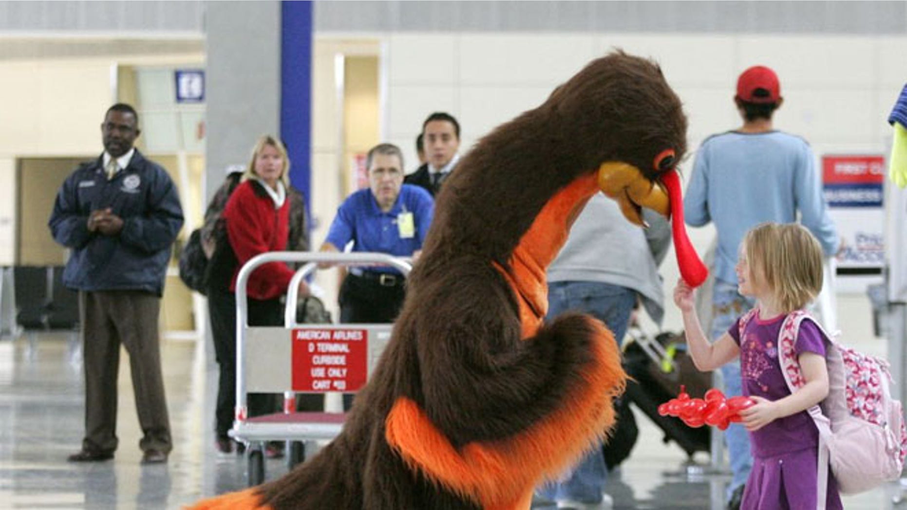 FILE: Abby Harris, 4, checks the wattle on a turkey greeting passengers at Dallas-Fort Worth International Airport in Grapevine, Texas.