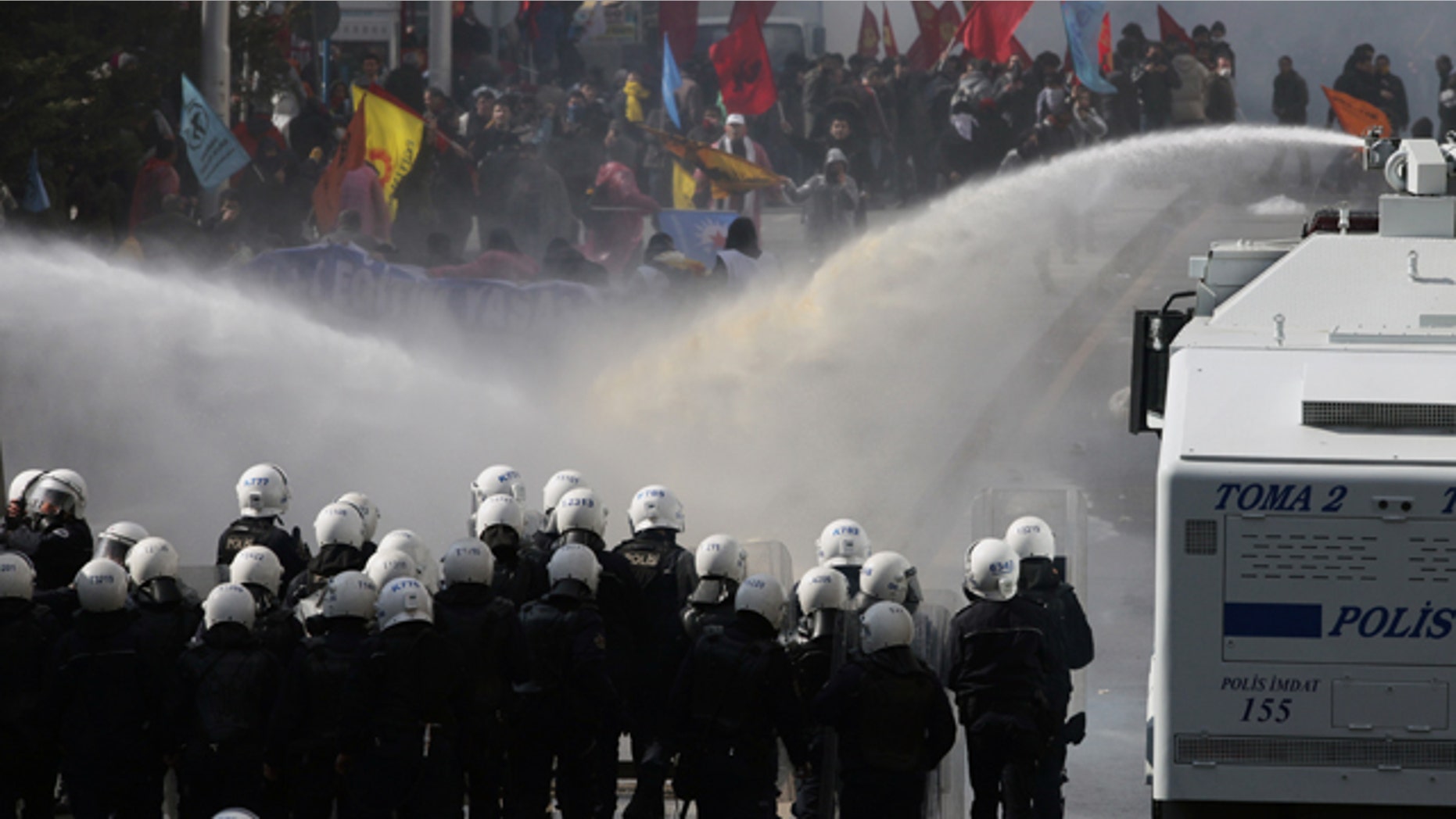 March 29, 2012: People run as Turkish police fire tear gas and water cannons to disperse thousands of people protesting an education reform bill that opponents say will boost the influence of Islamic schools, in Ankara, Turkey.