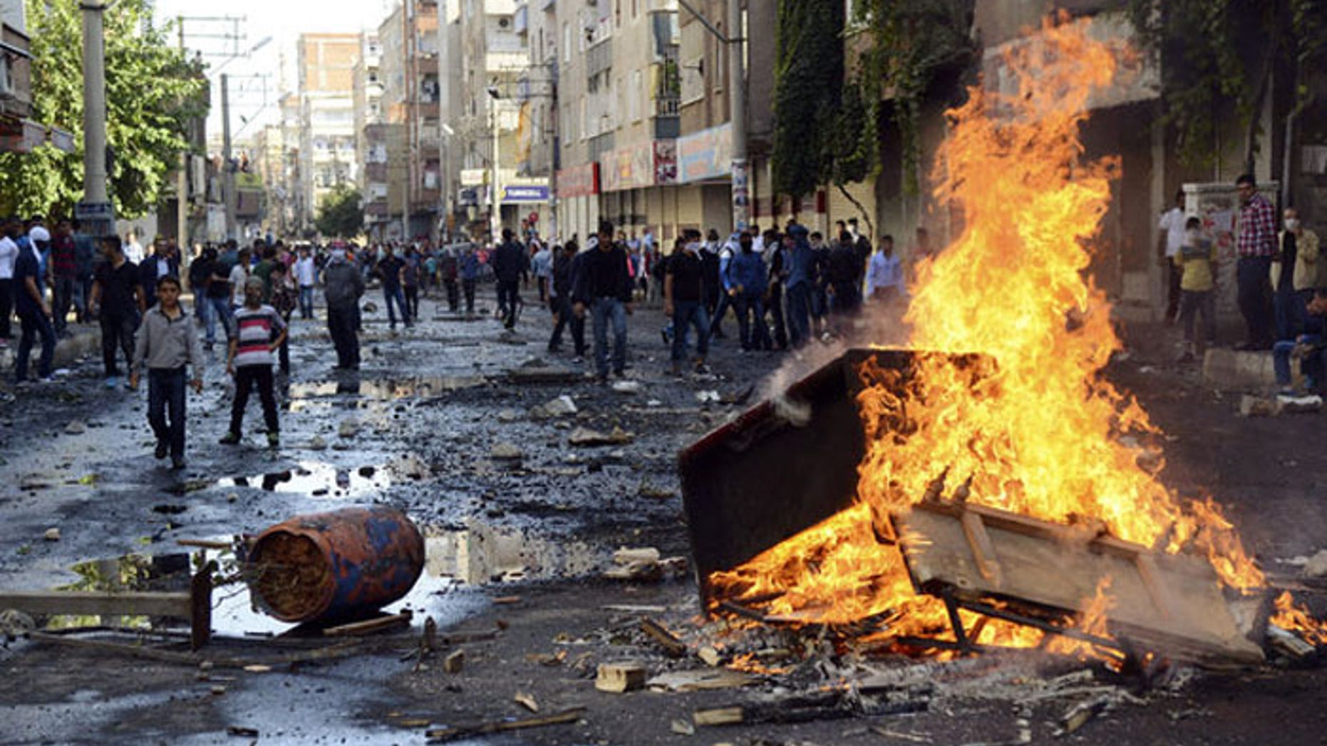 Kurdish protesters set fire to a barricade set up to block the street as they clash with riot police in Diyarbakir, Turkey. (Reuters)