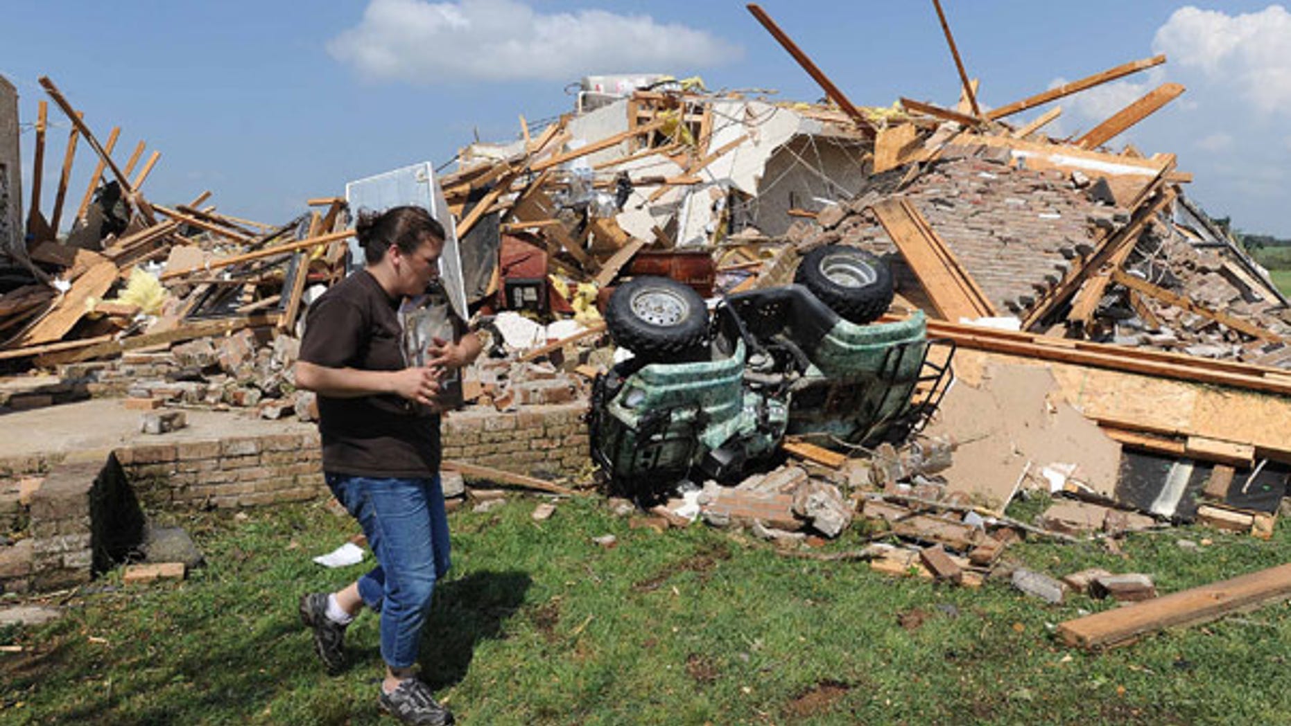 April 24: A woman helps her friend recover photos after a tornado swept through Holmes County, Miss.