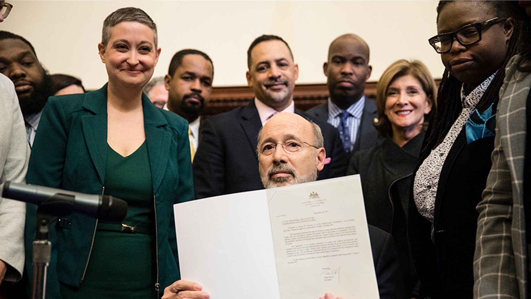 Pennsylvania Gov. Tom Wolf displays his signature after vetoing a bill passed by the Republican-controlled Legislature to limit abortions to the first 20 weeks of pregnancy at City Hall in Philadelphia, Monday, Dec. 18, 2017.