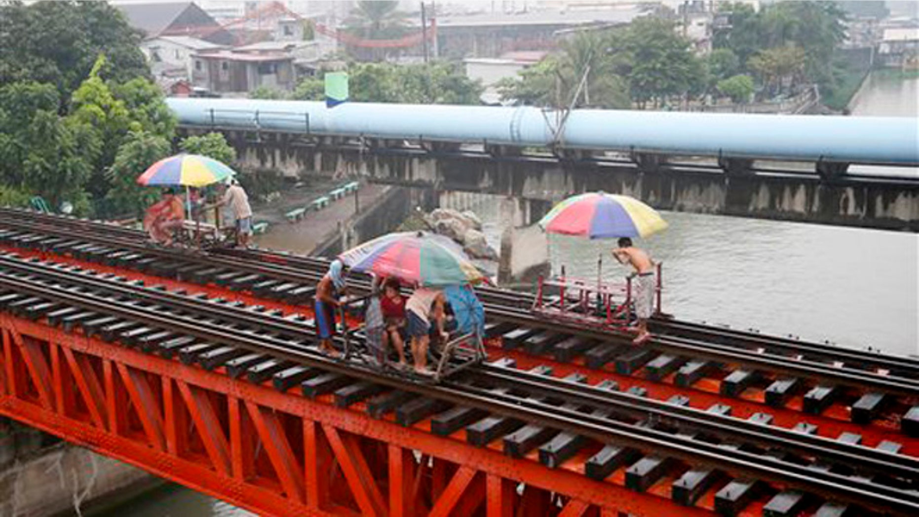 Oct. 17, 2015: Commuters ride on a locally-built cart known as "trolley" which makes use of a railroad track on a typhoon-induced rain in Manila, Philippines.