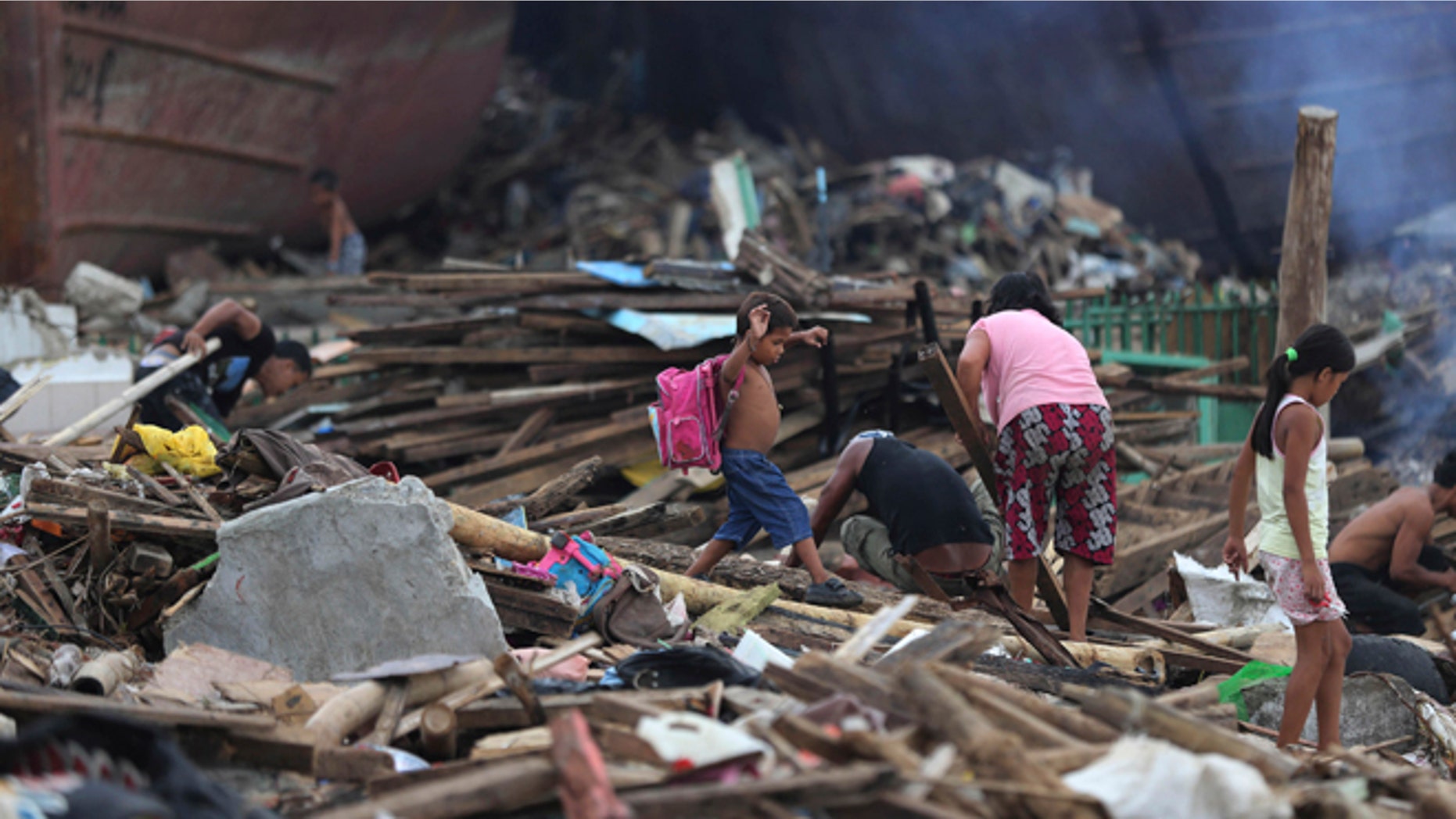 Dec. 7, 2013: A boy survivor carries a school bag as he walks by debris from damaged homes at typhoon ravaged Tacloban city, central Philippines.