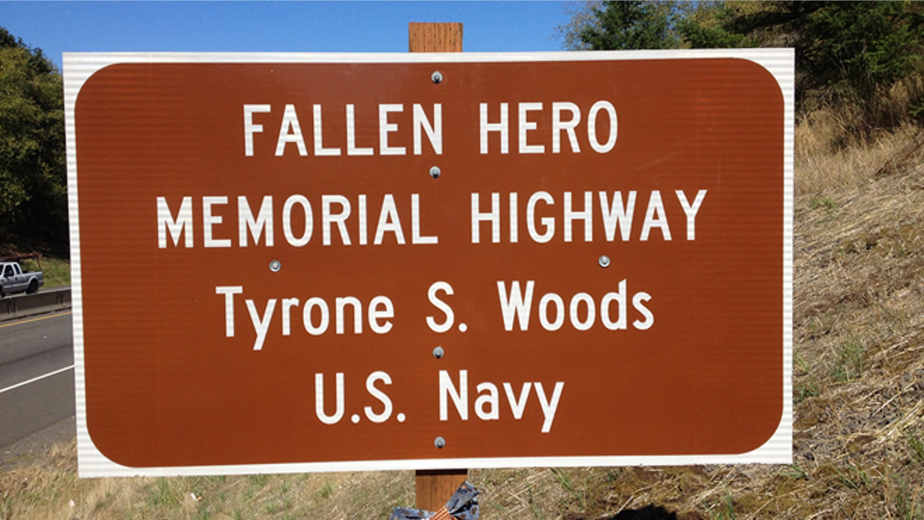 An Oregon sign reflects a stretch of highway dedicated in memory of Tyrone Woods, who was killed in the 2012 Benghazi attack.