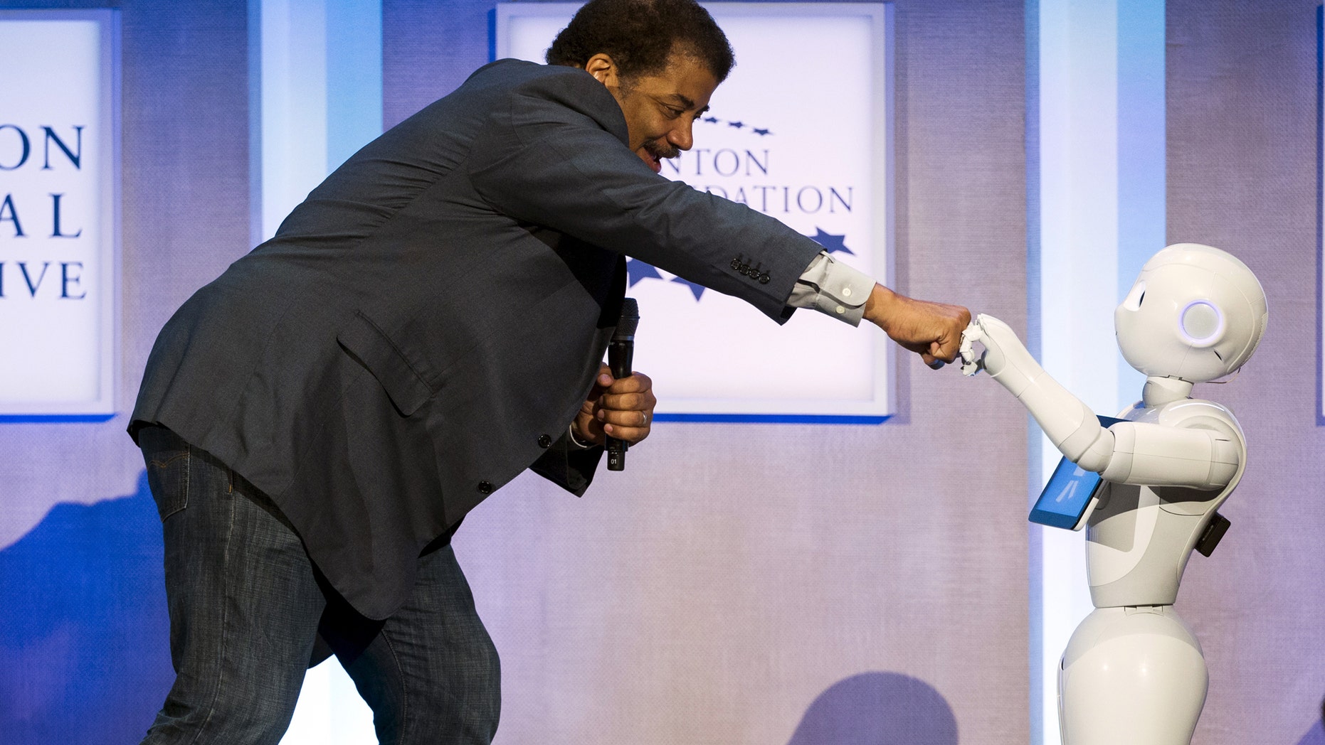File photo: Astrophysicist Neil deGrasse Tyson interacts with Pepper, a social humanoid robot developed by Aldebaran for SoftBank, during the Clinton Global Initiative's annual meeting in New York, September 28, 2015. (REUTERS/Lucas Jackson)