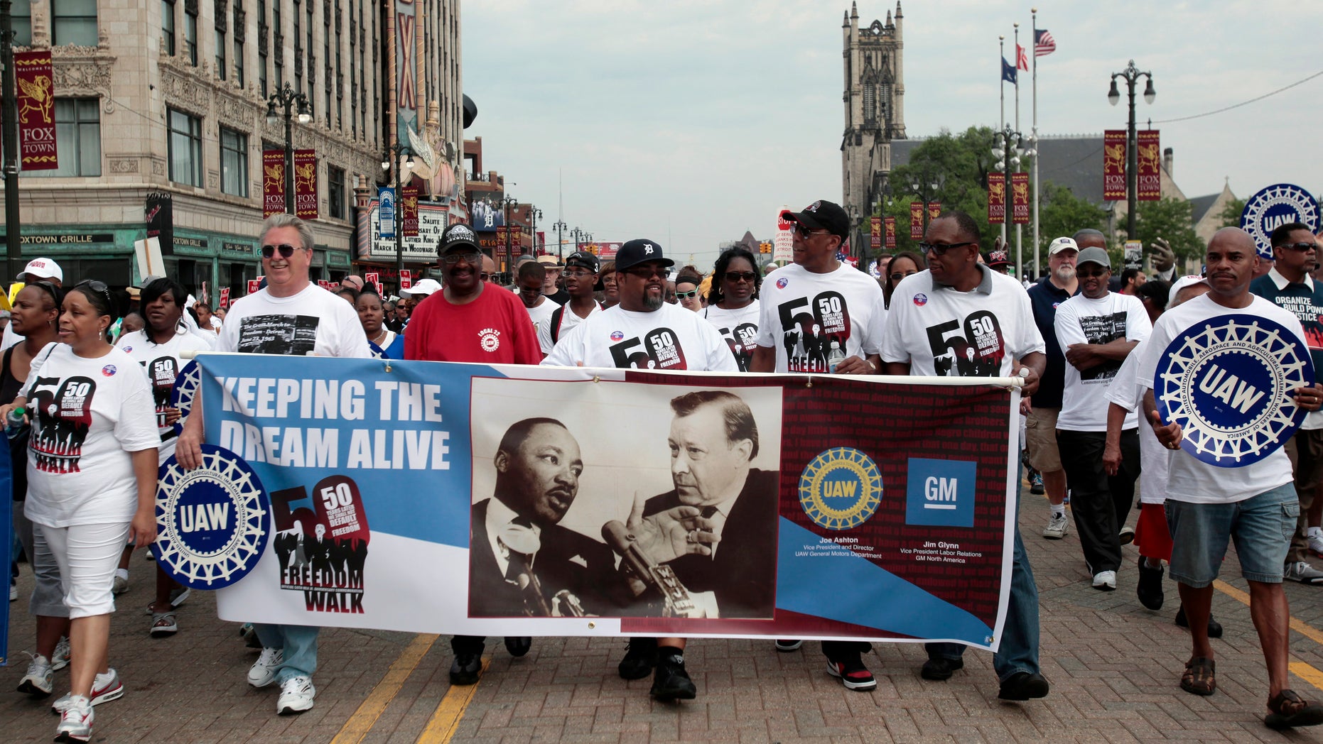 UAW union members carry a banner showing Martin Luther King Jr and labor leader Walter Reuther as they march down Woodward Avenue during the 50th Anniversary Commemorative Freedom Walk in Detroit, Michigan.