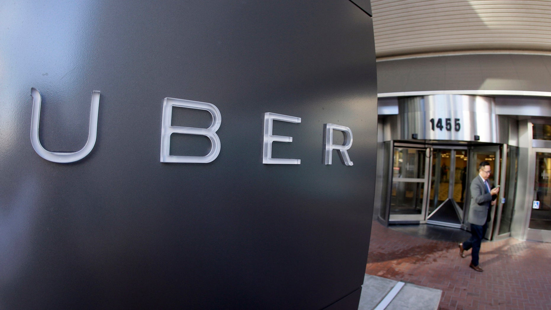 FILE - In this Dec. 16, 2014, file photo a man leaves the headquarters of Uber in San Francisco.