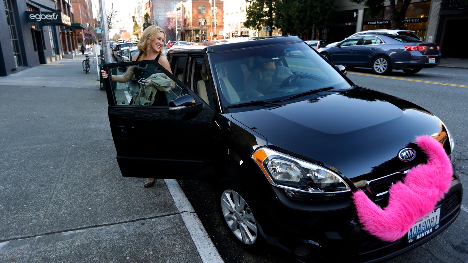 FILE - In this March 12, 2014 file photo, Katie Baranyuk gets out of a car driven by Dara Jenkins, a driver for the ride-sharing service Lyft, after getting a ride to downtown Seattle. Seattle may soon become the first city to let drivers of ride-hailing companies such as Uber and Lyft collectively bargain over pay and working conditions. (AP Photo/Ted S. Warren, File)
