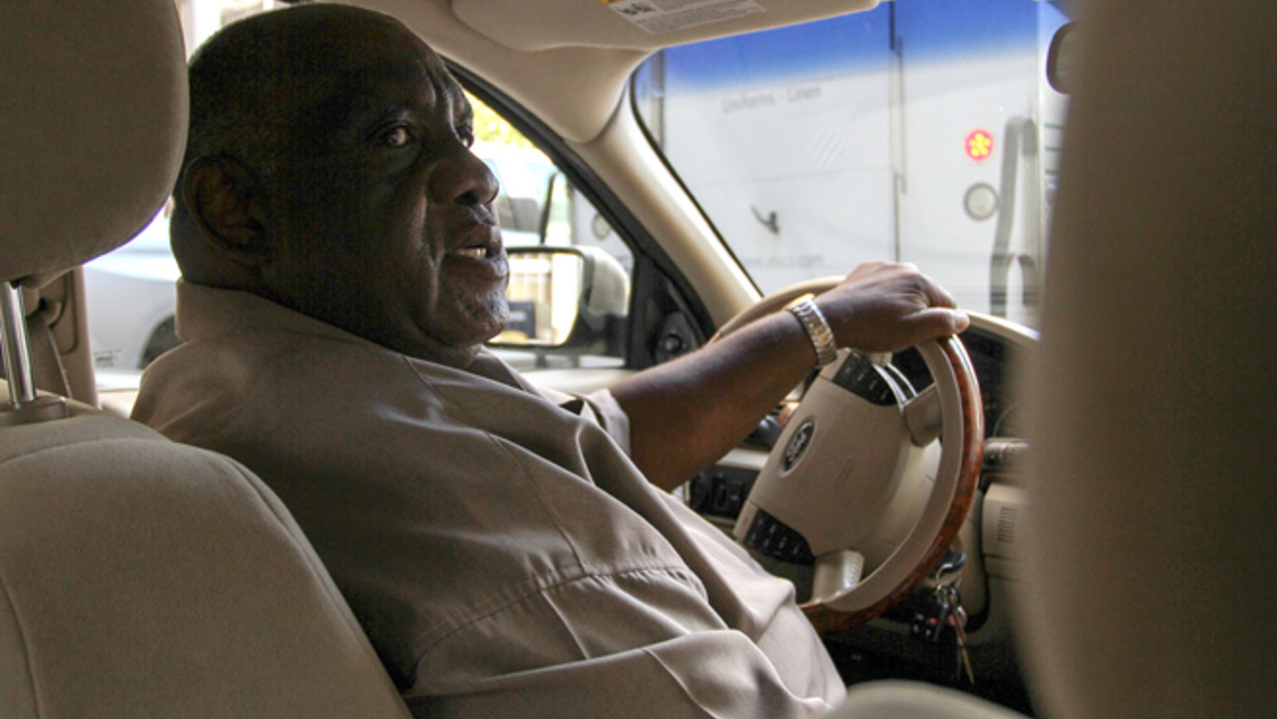 Retired bus driver Ellis Hill drives the car he uses as an Uber driver Thursday, Aug. 11, 2016, in Philadelphia. (AP Photo/Dake Kang)