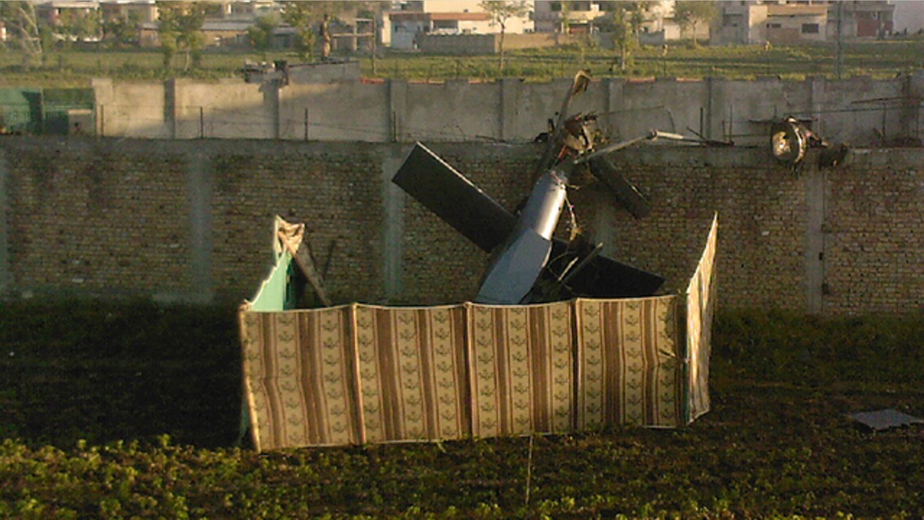 May 2: A photo taken by a local resident shows the wreckage of a helicopter next to the wall of the compound where, according to officials, Osama bin Laden was shot and killed in a firefight with U.S. forces in Abbottabad, Pakistan. Bin Laden, the glowering mastermind behind the Sept. 11, 2001, terror attacks that killed thousands of Americans, was slain in his luxury hideout in Pakistan early Monday. (AP/Mohammad Zubair)