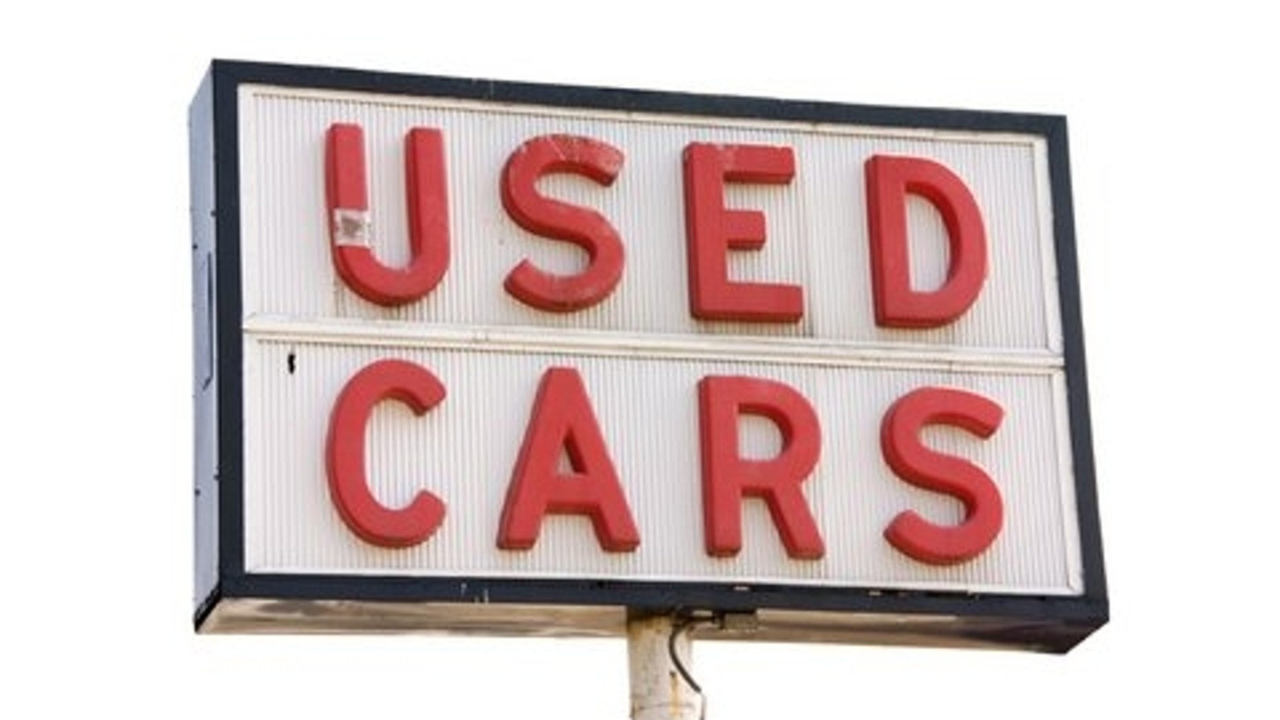 This is a picture of an old used cars sign with red letters, isolated on a white background.
