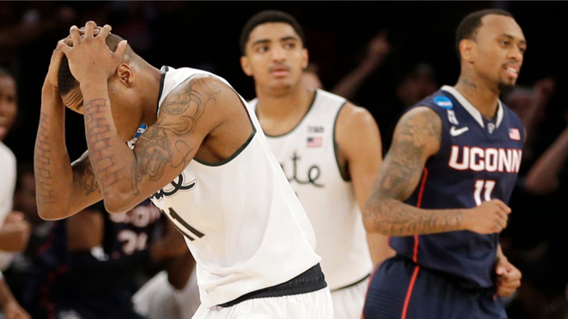 March 30, 2014: Michigan State's Keith Appling, left, reacts after losing to Connecticut 60-54 in a regional final at the NCAA college basketball tournament in New York.