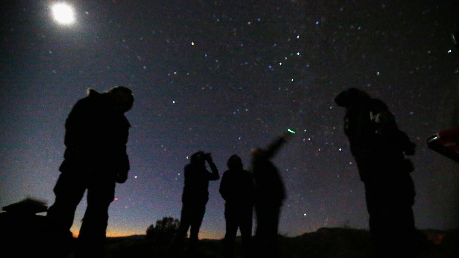 File photo - People look at the night sky using night vision goggles during an Unidentified Flying Object (UFO) tour in the desert outside Sedona, Arizona Feb. 14, 2013. (REUTERS/Mike Blake)