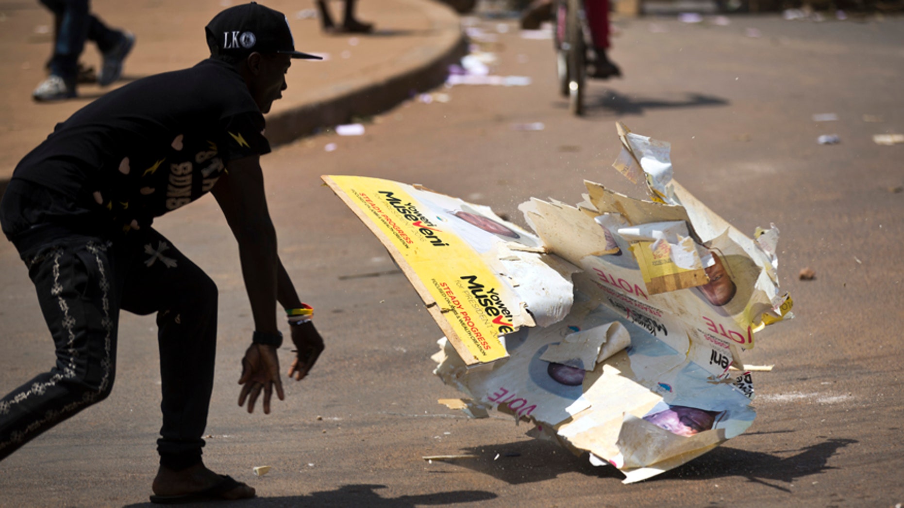 Feb. 18, 2016: An angry voter smashes a campaign placard of long-time President Yoweri Museveni, outside a polling station where voting material for the presidential election never arrived, at a polling station in Ggaba, on the outskirts of Kampala, in Uganda.