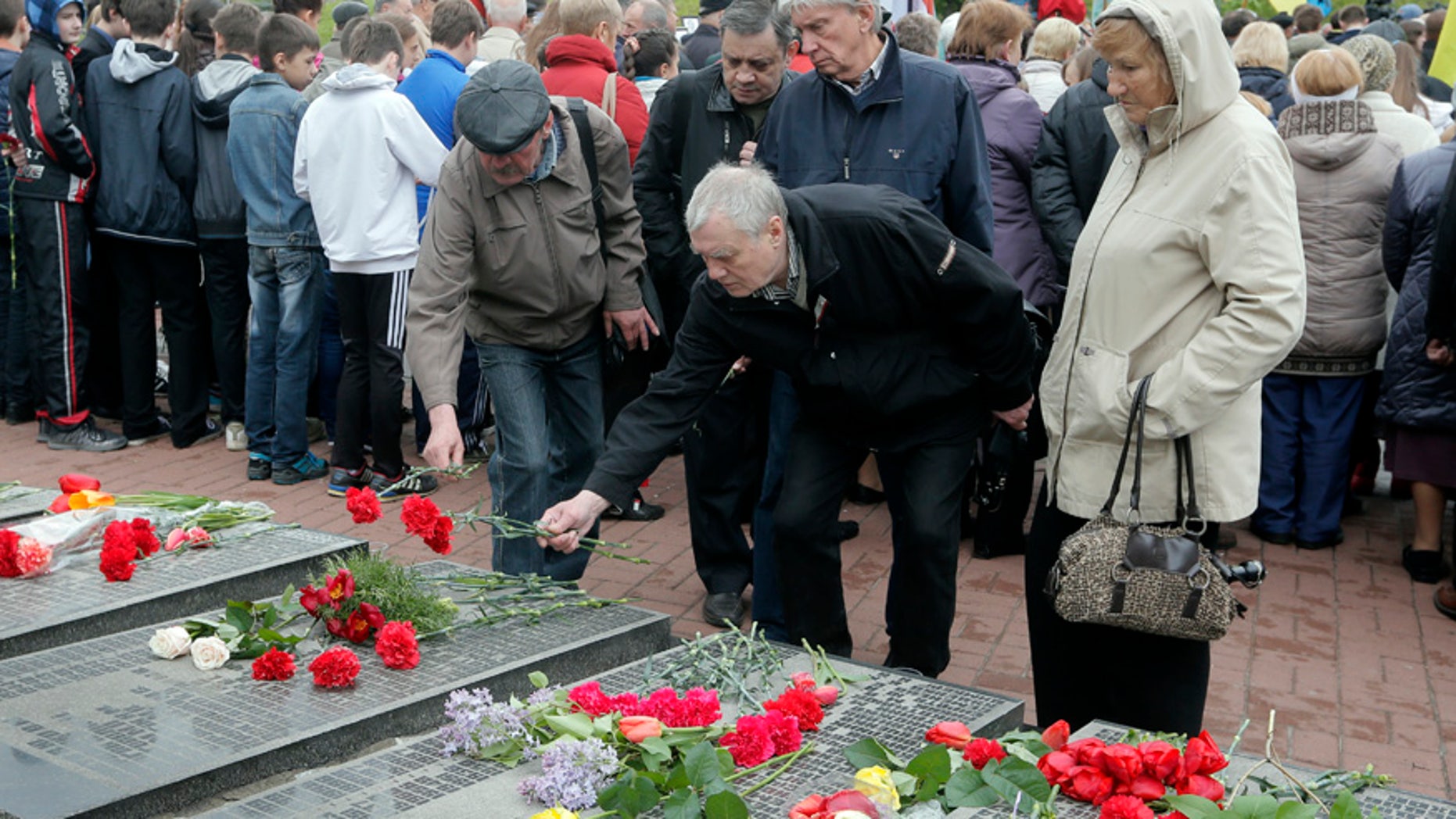 April 26, 2016: Ukrainians lay flowers to the tombstone that bears their relative's names, during a ceremony to commemorate victims of Chernobyl tragedy at a monument to them in Ukraine's capital Kiev, Ukraine.
