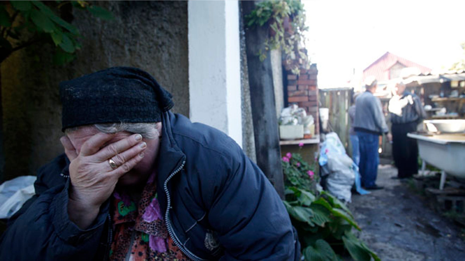 Sept. 19, 2014: Local resident Luba Zikova cries in front of her damaged house after shelling in the town of Donetsk, eastern Ukraine.