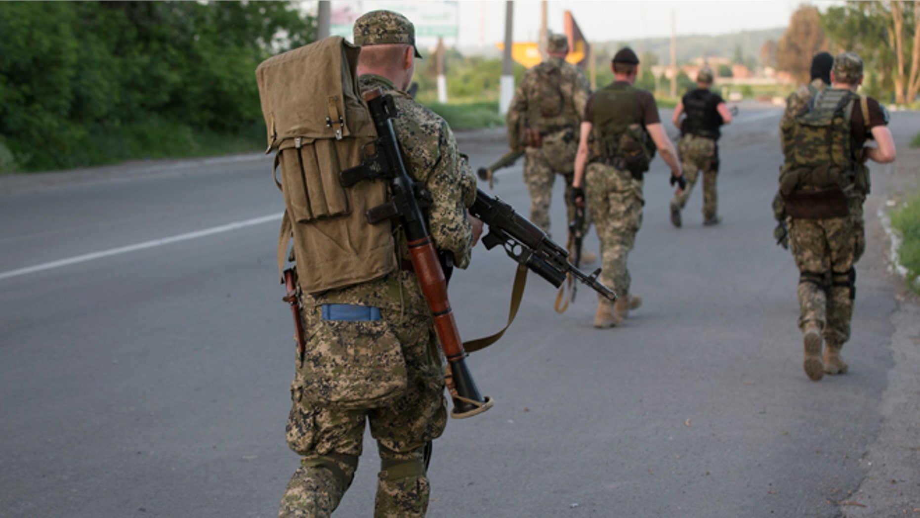 May 17, 2014: Pro-Russian militants walk to their positions to fight against Ukrainian government troops at a checkpoint blocking the major highway which links Kharkiv, outside Slovyansk, eastern Ukraine.