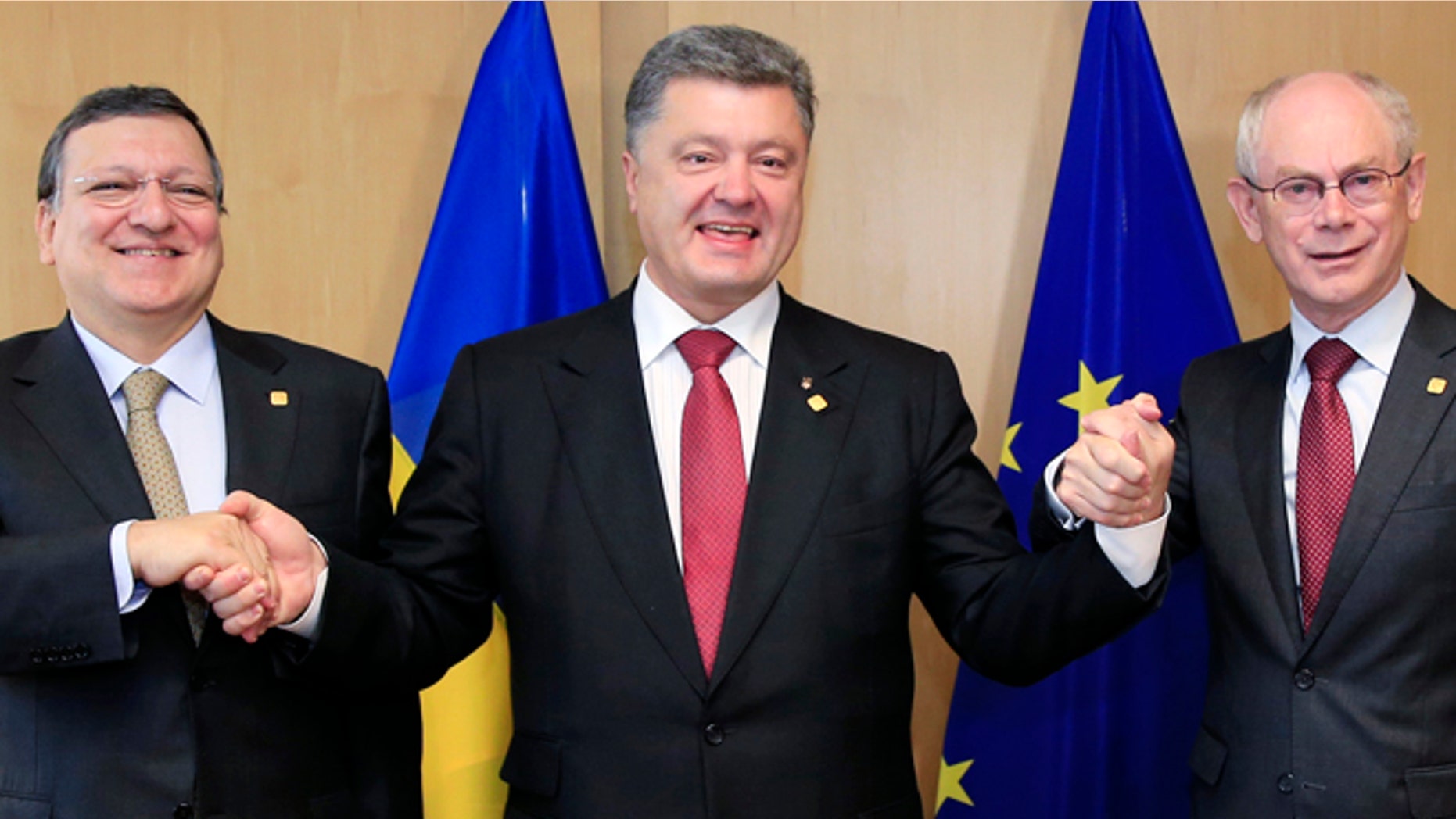 June 27, 2014: Ukraine's President Petro Poroshenko poses with European Commission President Jose Manuel Barroso (L) and European Council President Herman Van Rompuy (R) at the EU Council in Brussels.