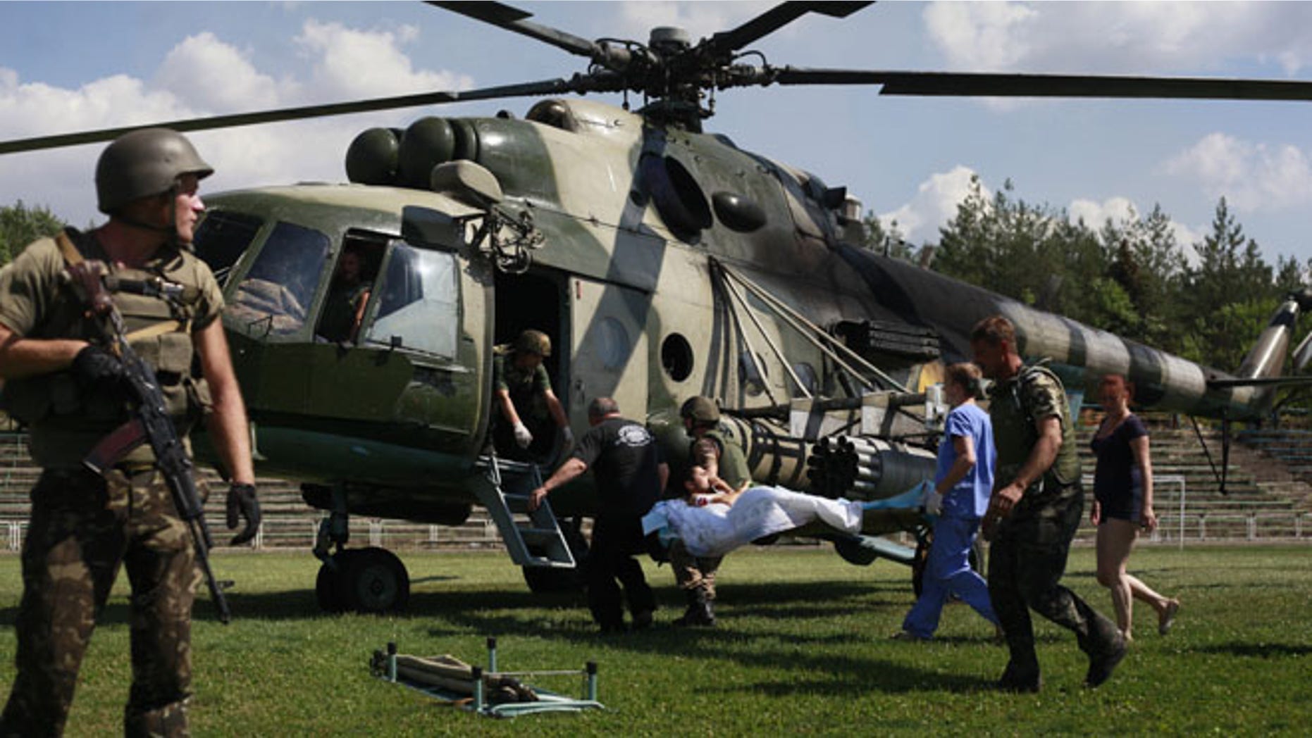 Ukrainian soldiers evacuate a wounded comrade close to Luhansk, eastern Ukraine, Thursday, Aug. 21, 2014. The rebel stronghold 20 kilometers from the Russian border has been under siege for 19 days, lacking basic amenities like running water or electricity. (AP Photo/Petro Zadorozhnyy)