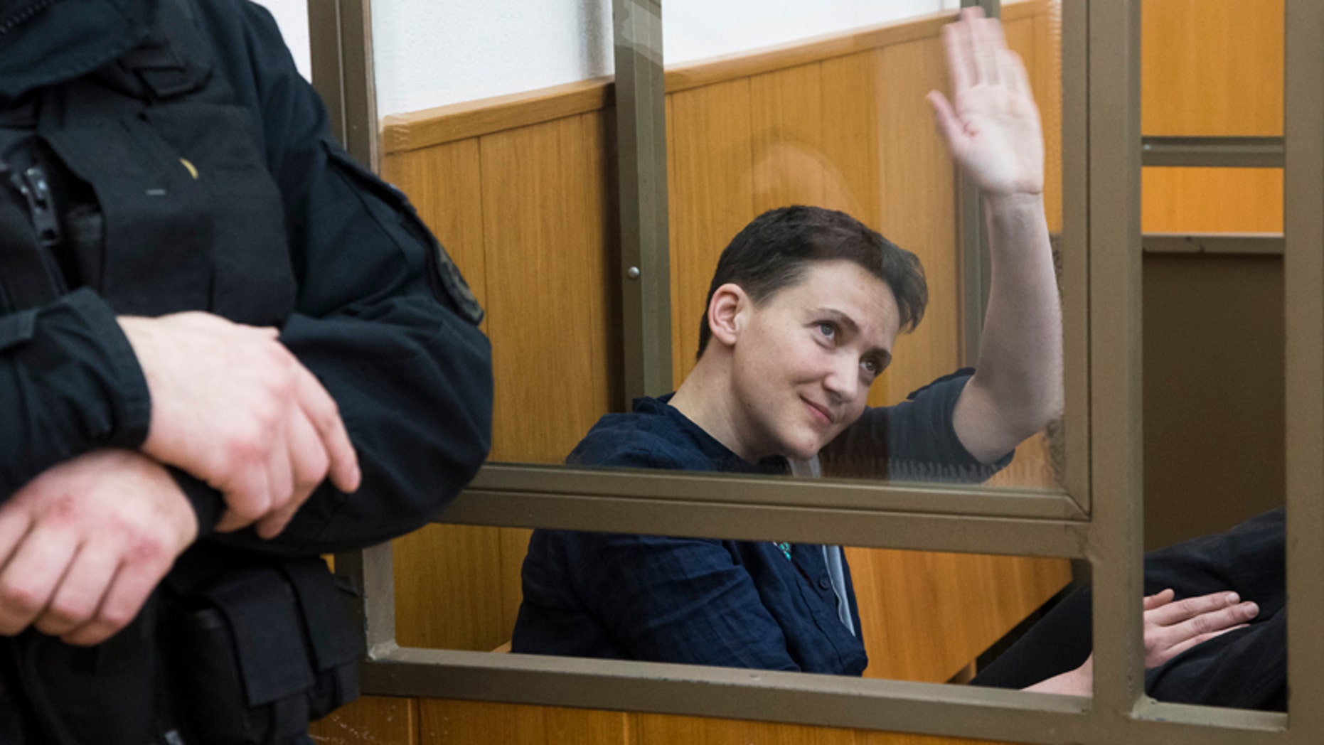March 22, 2016: Ukrainian pilot Nadezhda Savchenko waves to journalists from a glass cage inside court, in the town of Donetsk, Rostov-on-Don region, Russia.