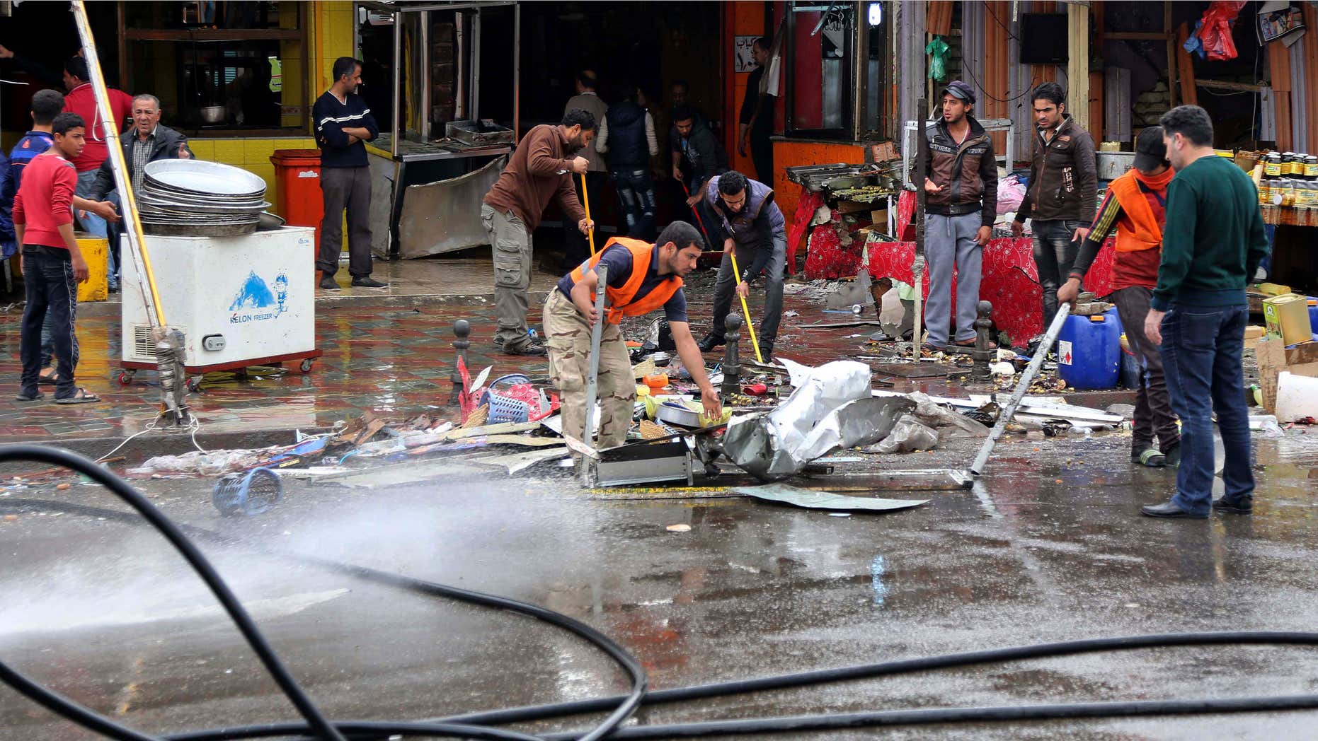 Feb. 7, 2015: Iraqis clean up the site of a suicide bombing that targeted a street filled with hardware stores, killing over 20 people and wounding at least 45, in the Iraqi capital's southeastern neighborhood of New Baghdad.