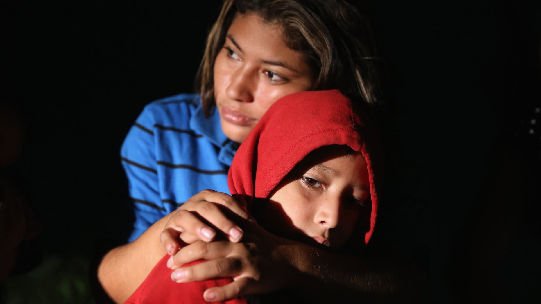 MISSION, TX - SEPTEMBER 08: Families of Central American immigrants, including Lorena Arriaga, 27, and her son Jason Ramirez, 7, from El Salvador, turn themselves in to U.S. Border Patrol agents after crossing the Rio Grande River from Mexico on September 8, 2014 to Mission, Texas. Although the numbers of such immigrant families and unaccompanied minors have decreased from a springtime high, thousands continue to cross in the border illegally into the United States. Texas' Rio Grande Valley sector is the busiest area for illegal border crossings, especially for Central Americans, into the U.S. (Photo by John Moore/Getty Images)