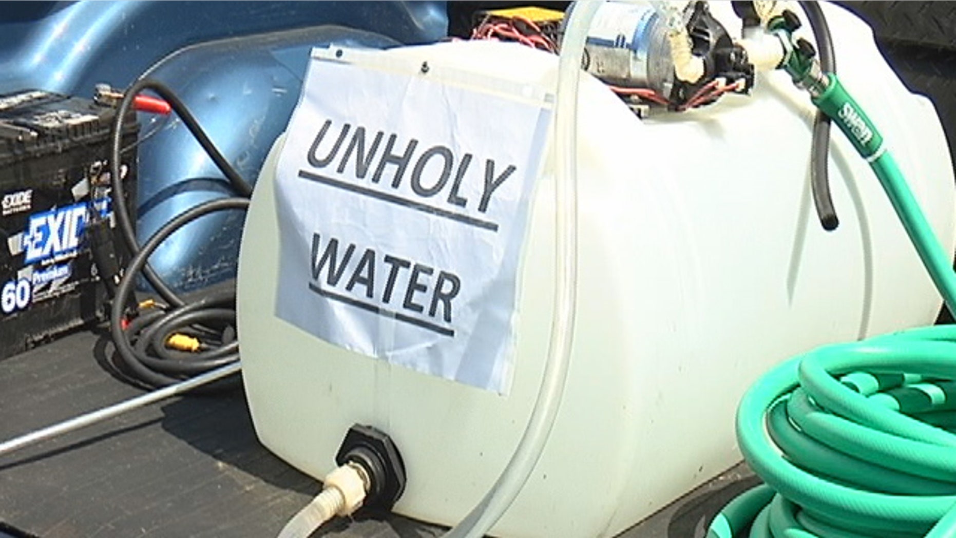 A group of athiests used 'unholy water' to wash away a religious group's blessing at the entryway to Polk County.