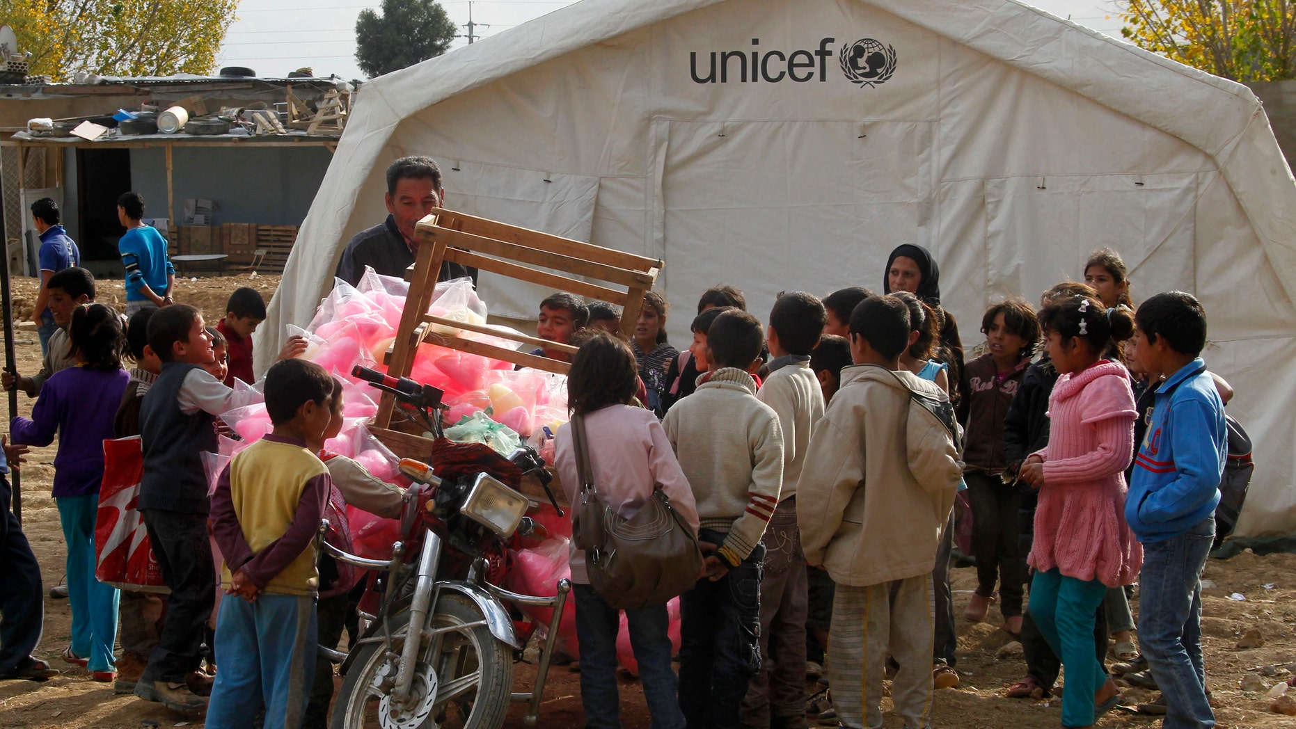 Syrian refugee children gather around a UNICEF tent at a Syrian refugee camp near Zahle town in the Bekaa Valley November 8, 2013. (REUTERS/Sharif Karim)