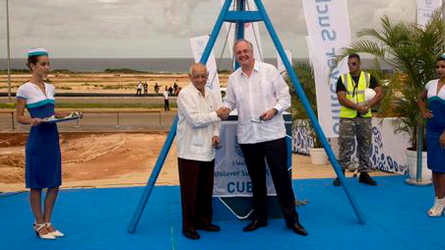 Unilever CEO Paul Polman, right, and Cuba's Minister of Industries Salvador Pardo, pose for photos after laying a cornerstone for a new business center, in Mariel, Cuba, Friday, Nov. 4, 2016. The Dutch consumer product giant has become one of the largest foreign companies to move into a special economic development zone at the Cuban port of Mariel that is meant to jumpstart outside investment on the island. (Ismael Francisco/Cubadebate via AP)