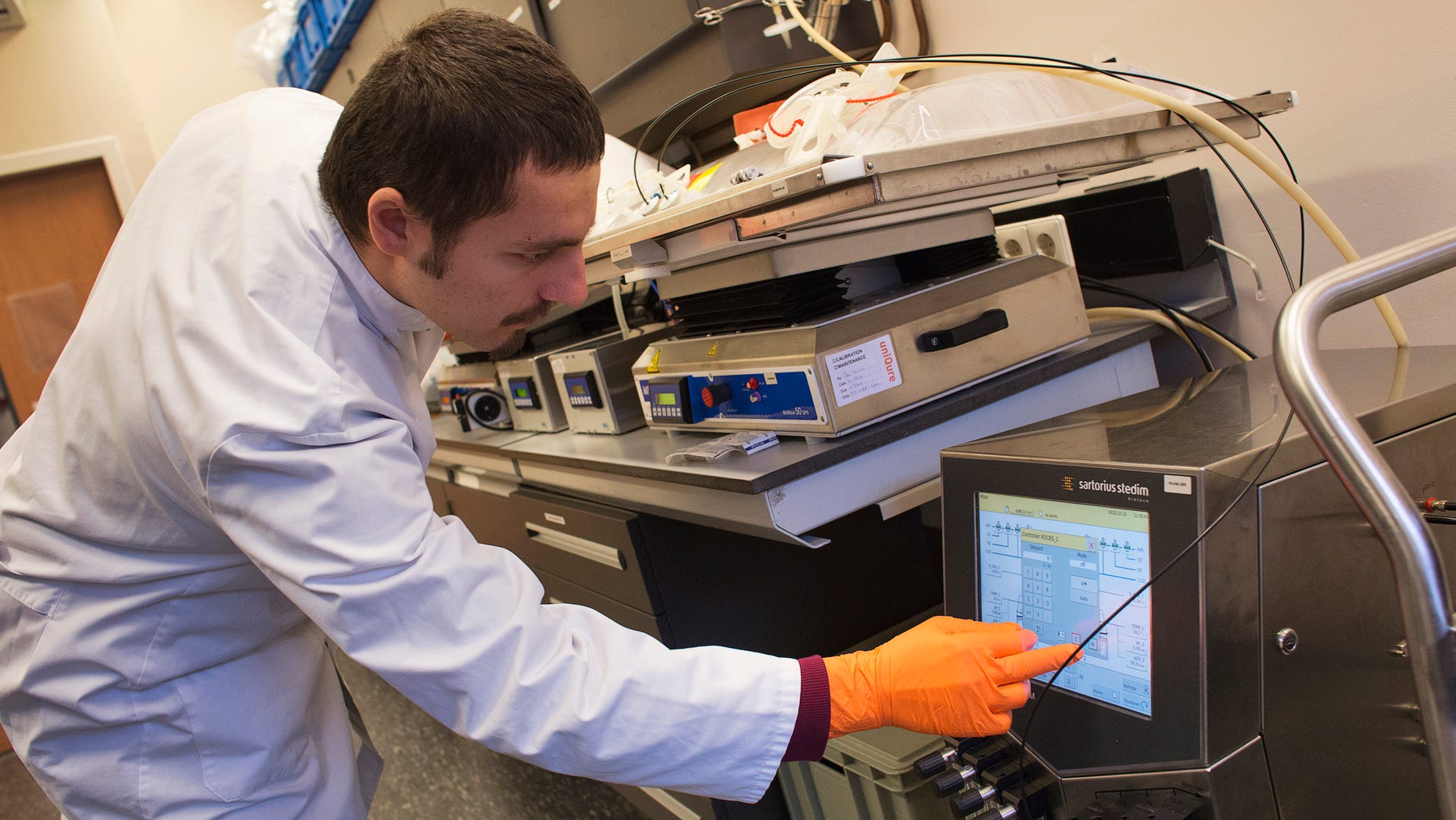 A uniQure bioprocessing engineer checks a monitor of a sterile disposable plastic cell culture bag as it is placed onto a rocking platform in a laboratory at Dutch biotech company uniQure in Amsterdam December 13, 2012. REUTERS/ Michael Kooren