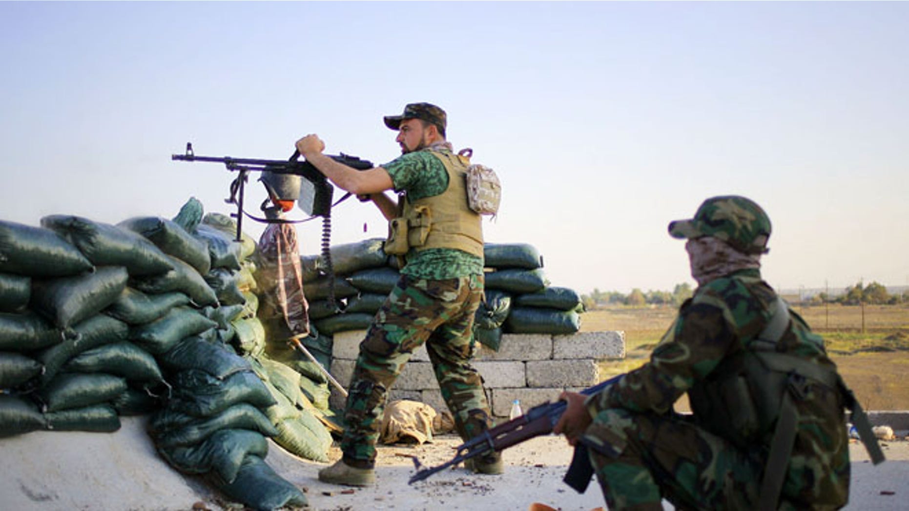 March 21, 2015: A volunteer fighter with a Shiite militant group aims his weapon during clashes with Islamic State group militants, outside Tikrit.