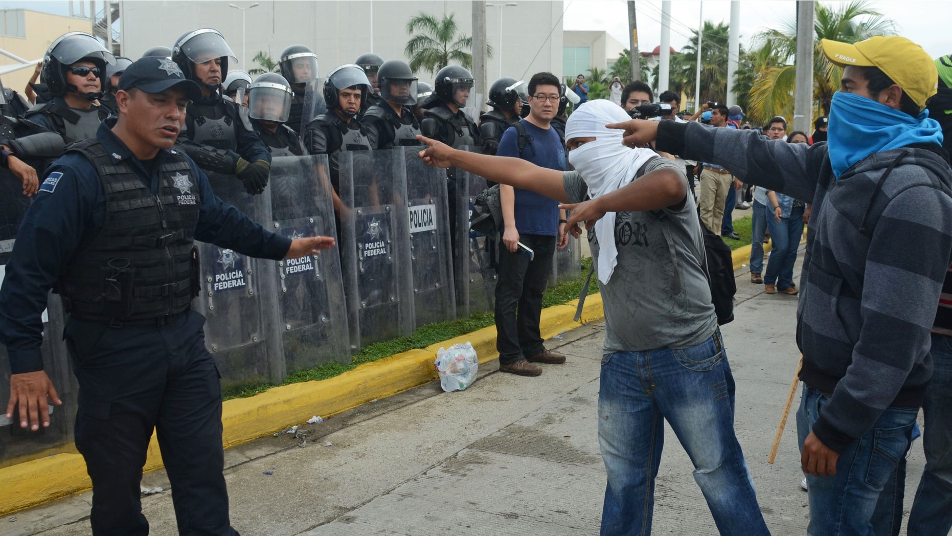 Nov. 10, 2014: Masked students confront federal police outside the Acapulco airport as they protest the disappearance, and probable murder, of 43 students in the state of Guerrero, Mexico