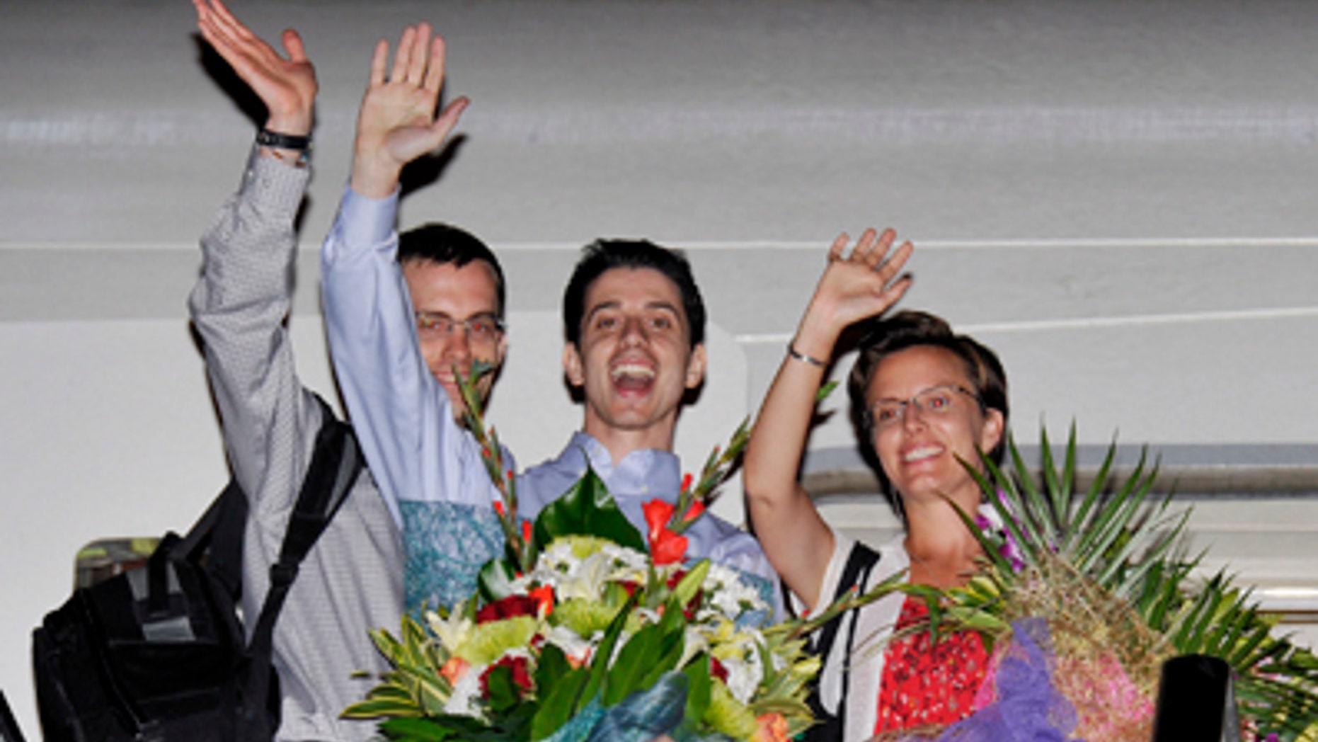 Sept. 24: Freed Americans Shane Bauer, left, Josh Fattal, center, and Sarah Shourd, right, Bauer's fiance, wave from the door to an airplane before leaving for the United States at the airport in Muscat, Oman.