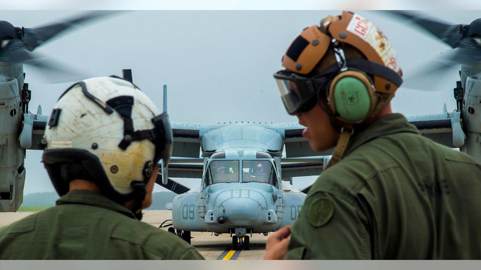 U.S. Marine Corps Cpl. Brandon Guico, a Marine Medium Tiltrotor Squadron 262 airframe aerial observer, and William Payne, a VMM-262 avionics technician, watch a MV-22 Osprey takeoff at Misawa Air Base, Japan last month.