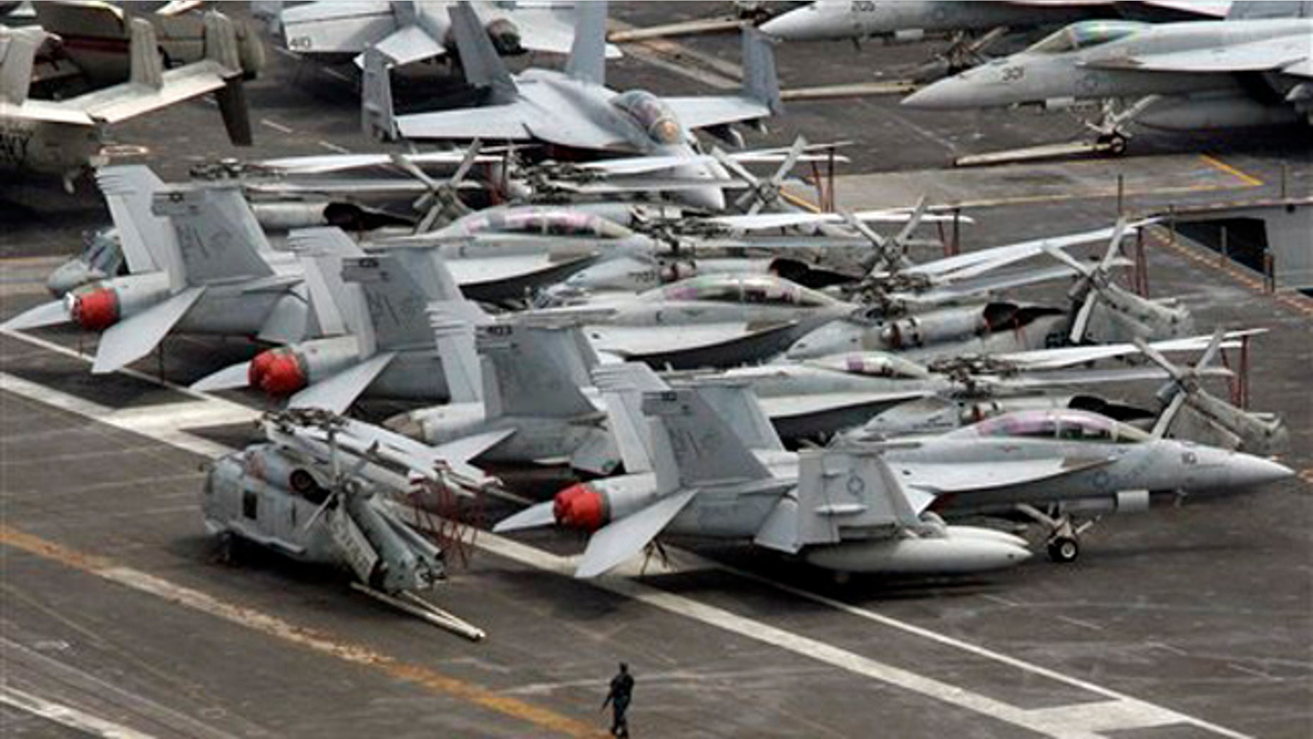 July 24, 2010: An armed military personnel stands near a flight line on the deck of U.S. nuclear-powered aircraft carrier USS George Washington at the Busan port in Busan, south of Seoul, South Korea.